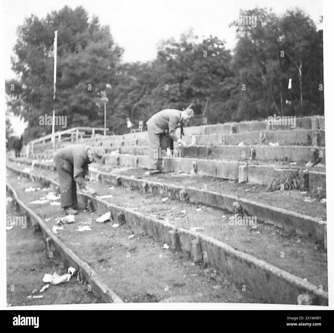 SERVIZIO COMBINATO XI contro WOLVERHAMPTON F.C. - i tedeschi cercano tra i rifiuti lasciati dalle truppe, alla ricerca di estremità di sigarette e scarti di cibo, British Army of the Rhine Foto Stock