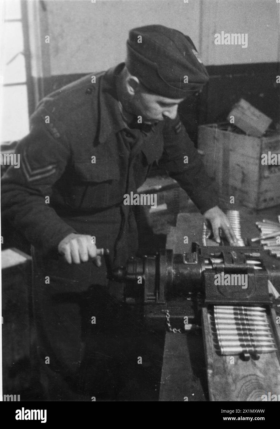 Un corazzatore di uno squadrone di caccia polacco in Gran Bretagna carica una cintura di munizioni da 12,7 mm in una mitragliatrice AN/m2 Browning su un aereo P-51 Mustang, il 20 dicembre 1944. Foto Stock