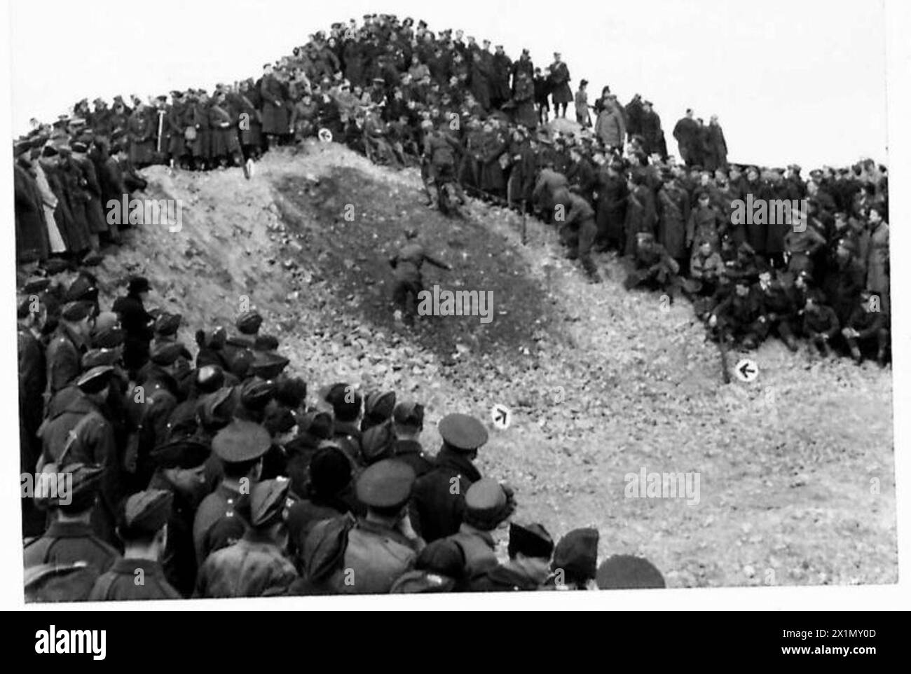 Gli spettatori militari osservano i concorrenti che navigano in una sezione impegnativa del corso di prova motociclistica dell'esercito in Irlanda del Nord, British Army. Foto Stock