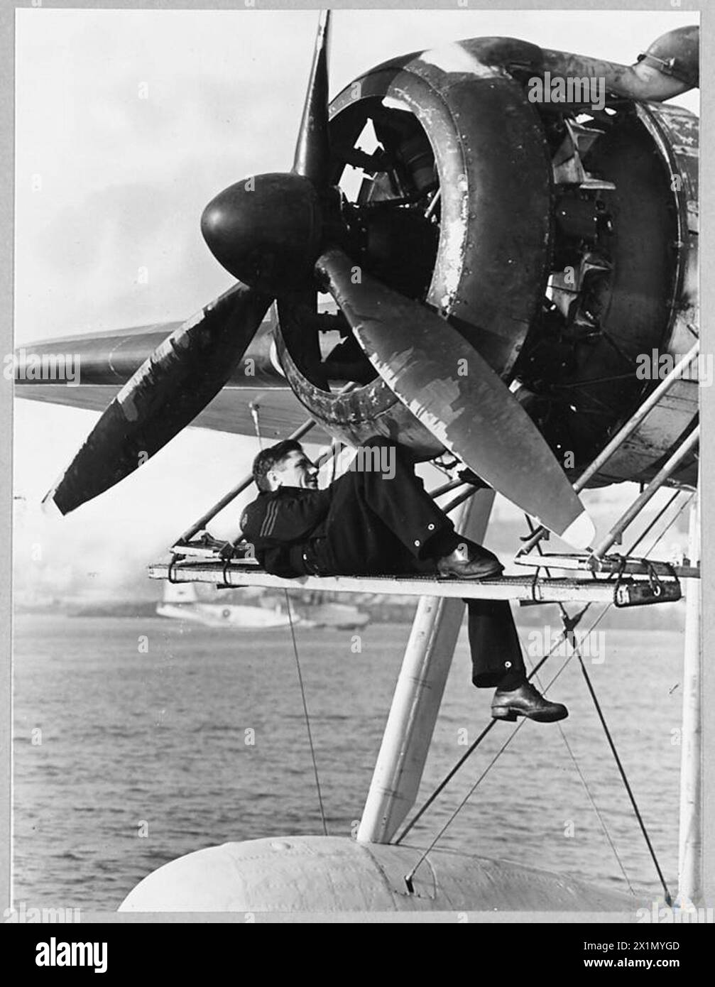 Un ingegnere di volo serve uno dei quattro motori di un aereo Sunderland dalle piattaforme di manutenzione mentre era in operazioni Coastal Command. Foto Stock