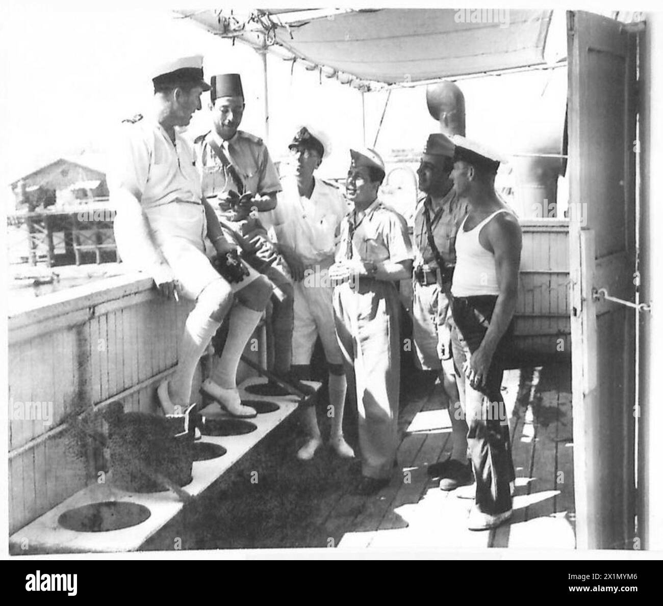Il capitano inglese della nave italiana "Verbena" parla con corrispondenti egiziani a bordo, durante le operazioni navali dell'esercito britannico. Foto Stock