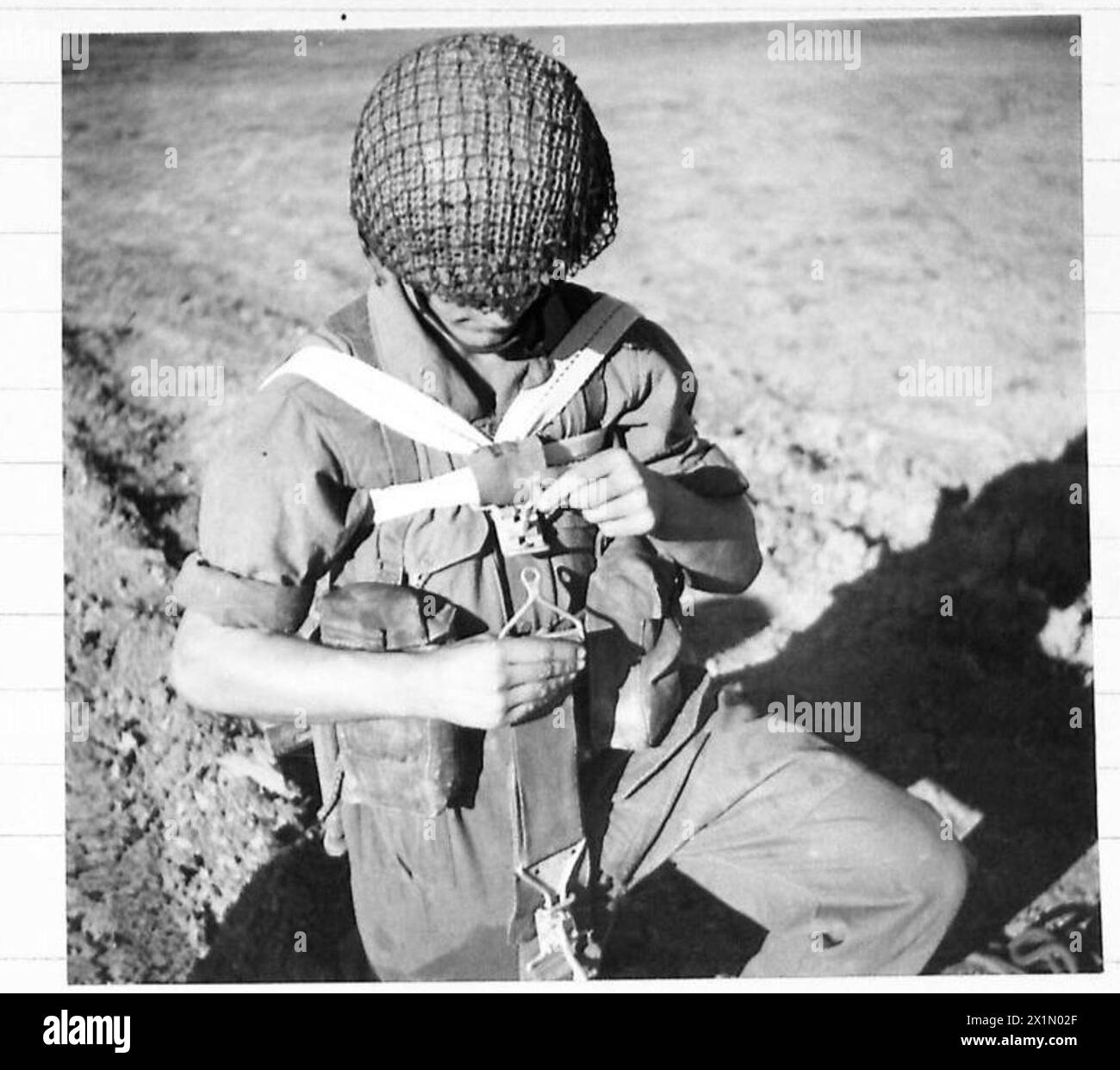 Il tenente T.W. Willans del 1st Independent Parachute Platoon dimostra un'imbracatura da paracadute adattata da una cintura di sicurezza per aerei C-47 Douglas, assistita da Private Bates. Foto Stock