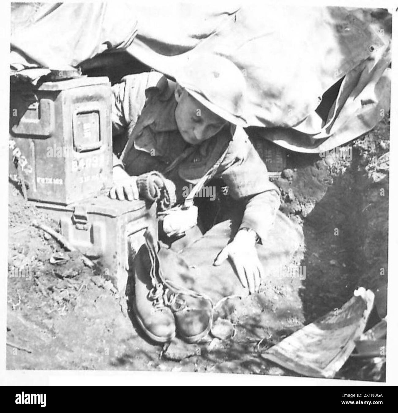 Il Sgt. Trainor si prepara alla pattuglia di fanteria alla testa di ponte di Anzio, utilizzando stivali con suola in crepe per un movimento silenzioso e copriberretto per camuffamento al posto dei caschi in acciaio. Foto Stock