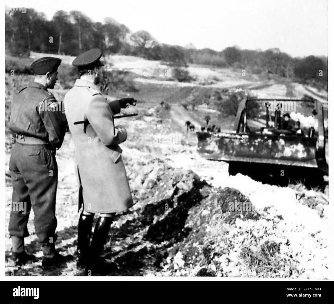 Sua Maestà il Re osserva un bulldozer gestito dal personale dell'esercito britannico durante una visita delle truppe d'invasione. Foto Stock