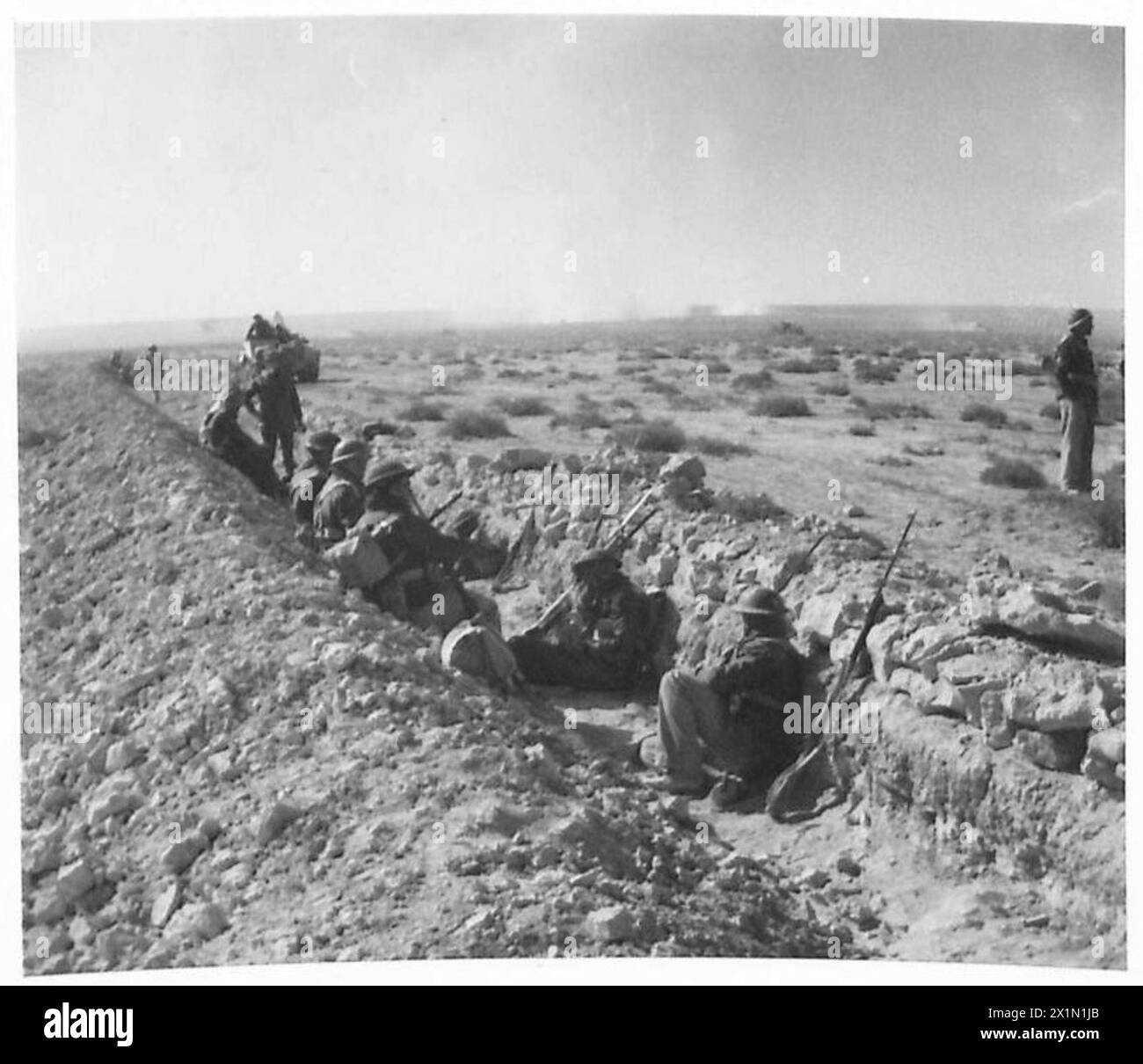 Le truppe dell'esercito britannico riposano in una trappola per carri armati italiana prima di avanzare a Tobruk durante la seconda guerra mondiale Foto Stock