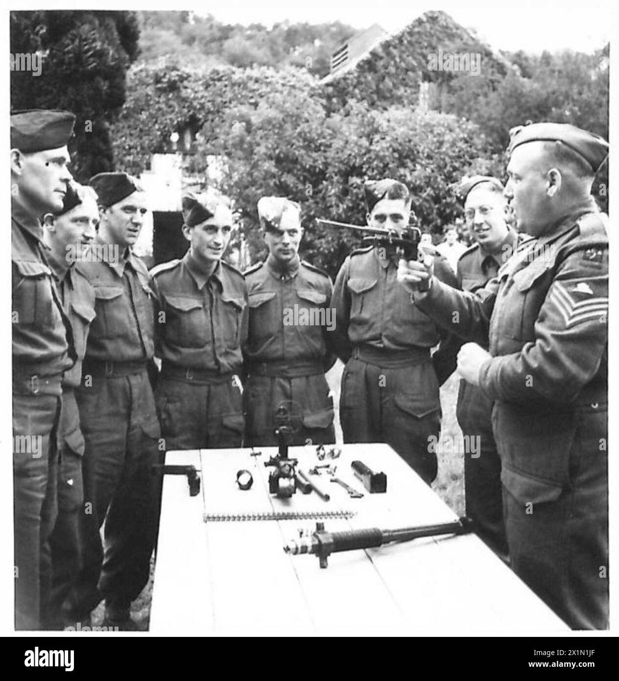 Un istruttore di sergente dimostra la pistola Hotchkiss ai giovani cannoni in un'esercitazione di addestramento dell'unità di artiglieria marittima, British Army. Foto Stock