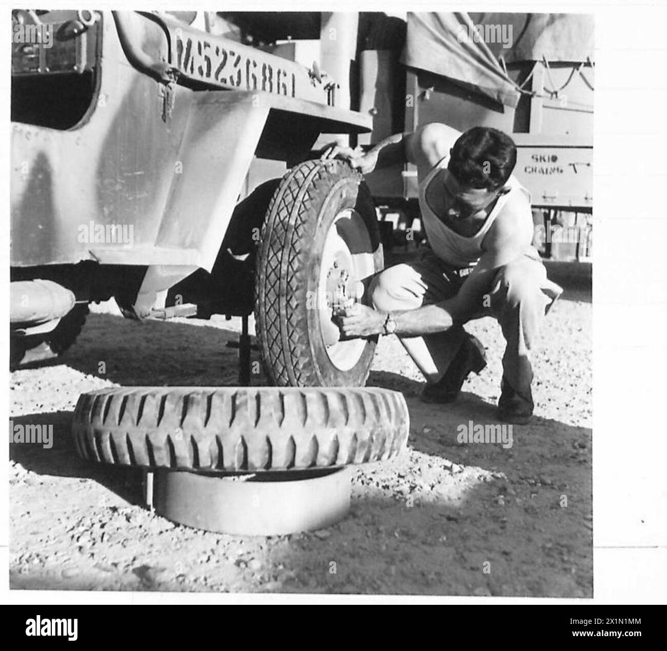 L'autista Tarrant della British Expeditionary Force cambia le gomme delle jeep in battistrada poco profondo per le operazioni nel deserto contro le locuste in Medio Oriente, sostituendo le motociclette per i compiti di spedizione. Foto Stock
