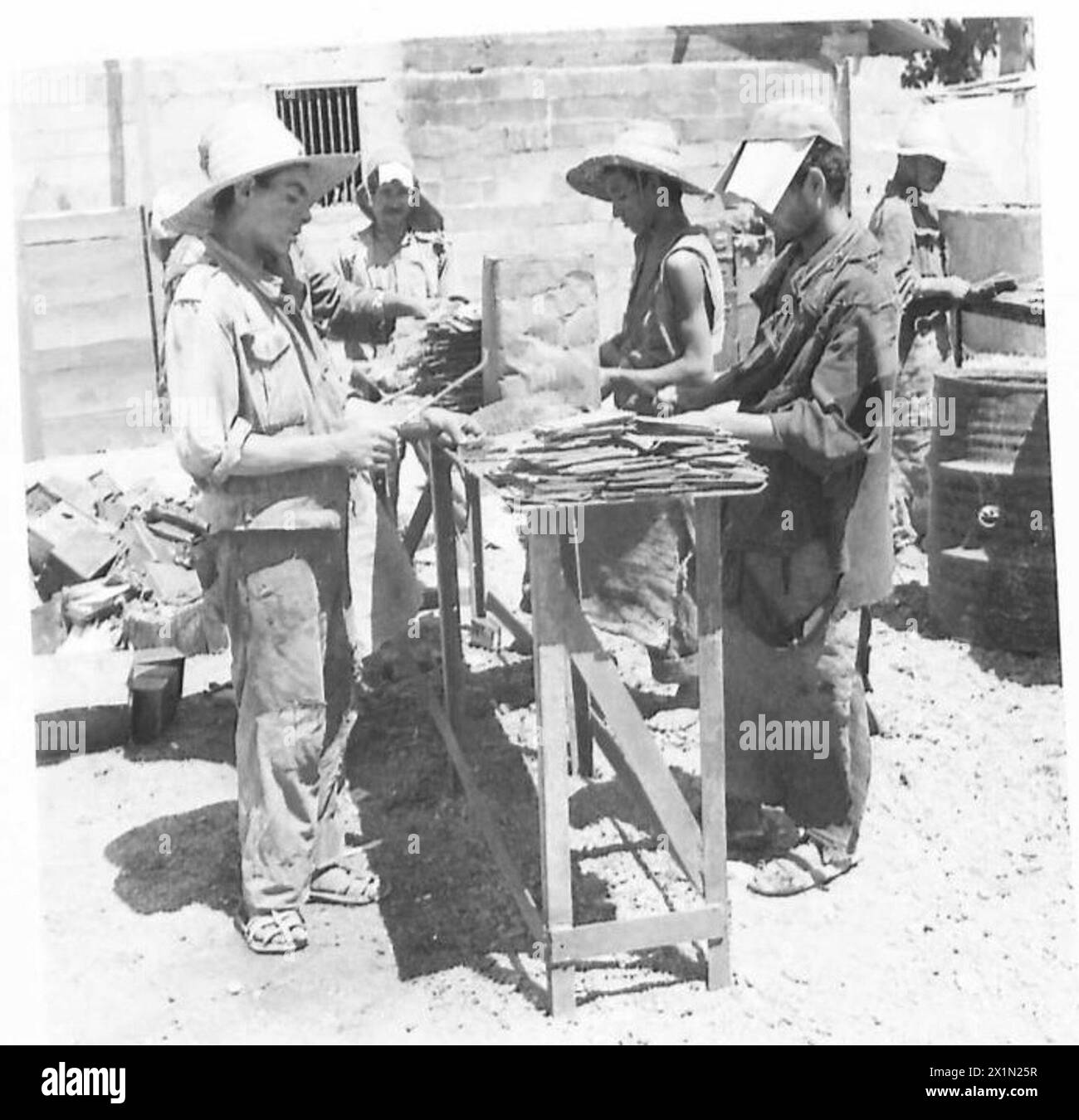 I lavoratori arabi rimuovono il carbonio dalle piastre della batteria come parte delle operazioni di salvataggio sotto la supervisione dell'esercito britannico. Foto Stock