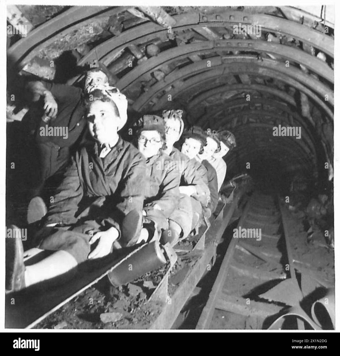 GLI AUSILIARI ATS VISITANO LA MINIERA DI CARBONE SCOZZESE, tutti a bordo del nastro trasportatore del carbone. Durante il tour, gli ausiliari ATS in visita sono visti attraversare la miniera, British Army Foto Stock