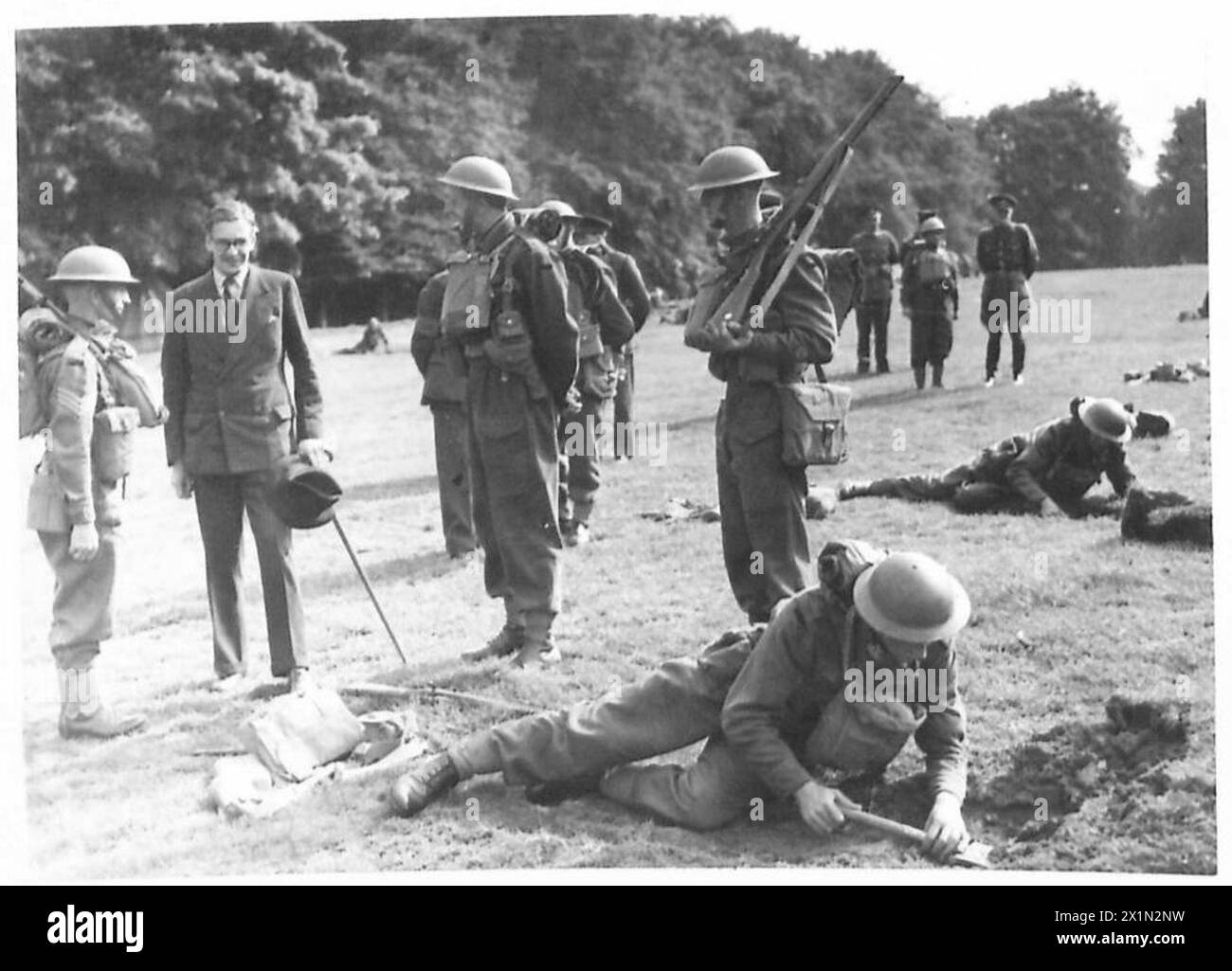 Il signor Eden osserva i soldati del 7th Royal Warwickshire Regiment scavando trincee in aree di difesa e addestramento, British Army. Foto Stock