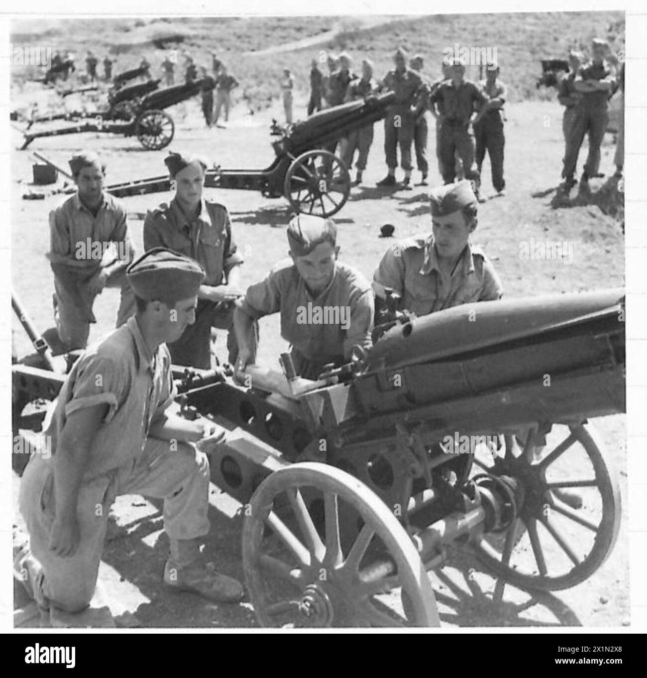 I mitraglieri dell'esercito britannico addestrano i partigiani nel caricamento e nella gestione dei cannoni d'artiglieria. Foto Stock