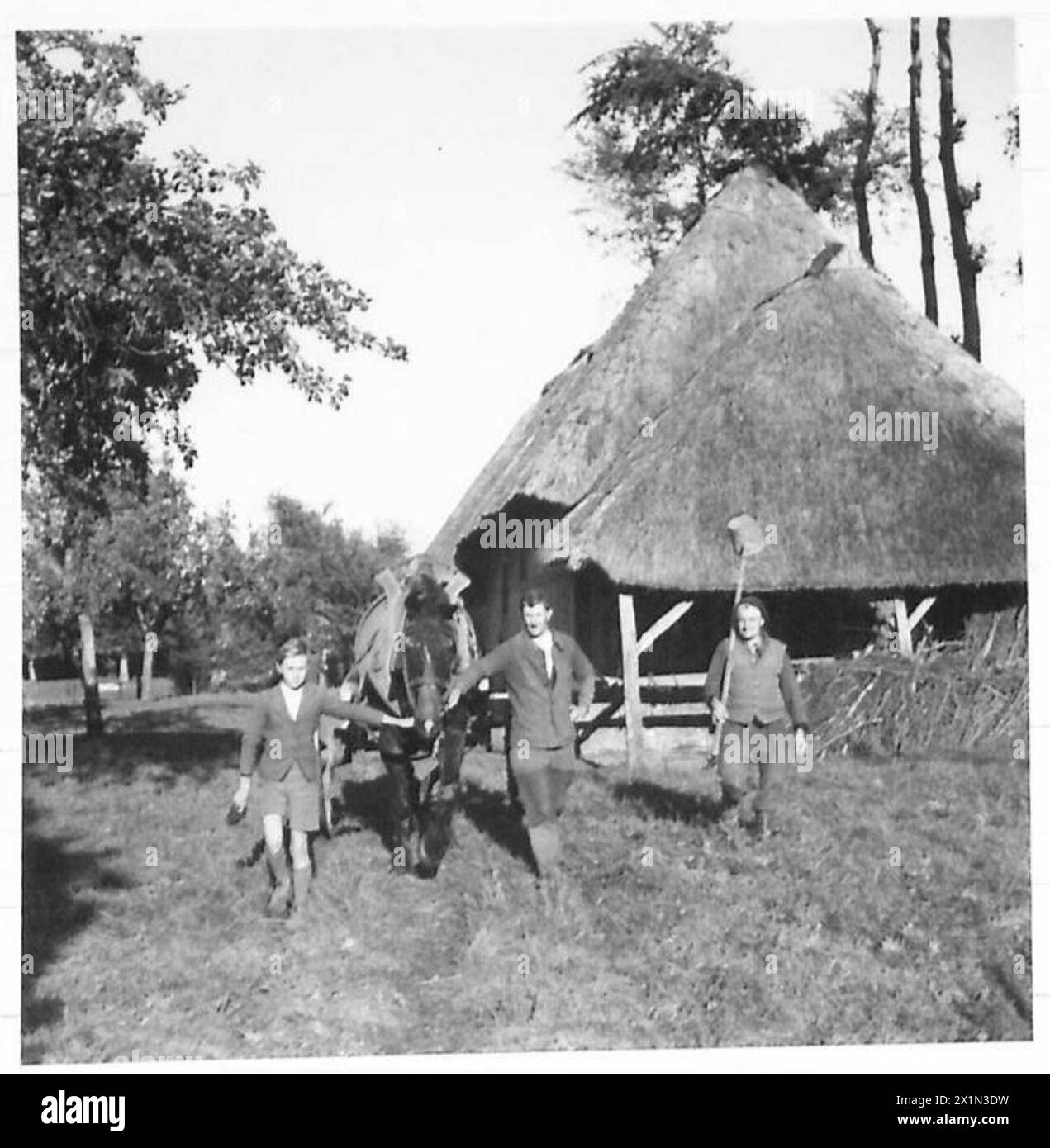 Le mani della fattoria in una fattoria della Bretagna trasportano l'acqua da un pozzo continuando le attività agricole quotidiane durante le operazioni supportate dal 21st Army Group dell'esercito britannico. Foto Stock