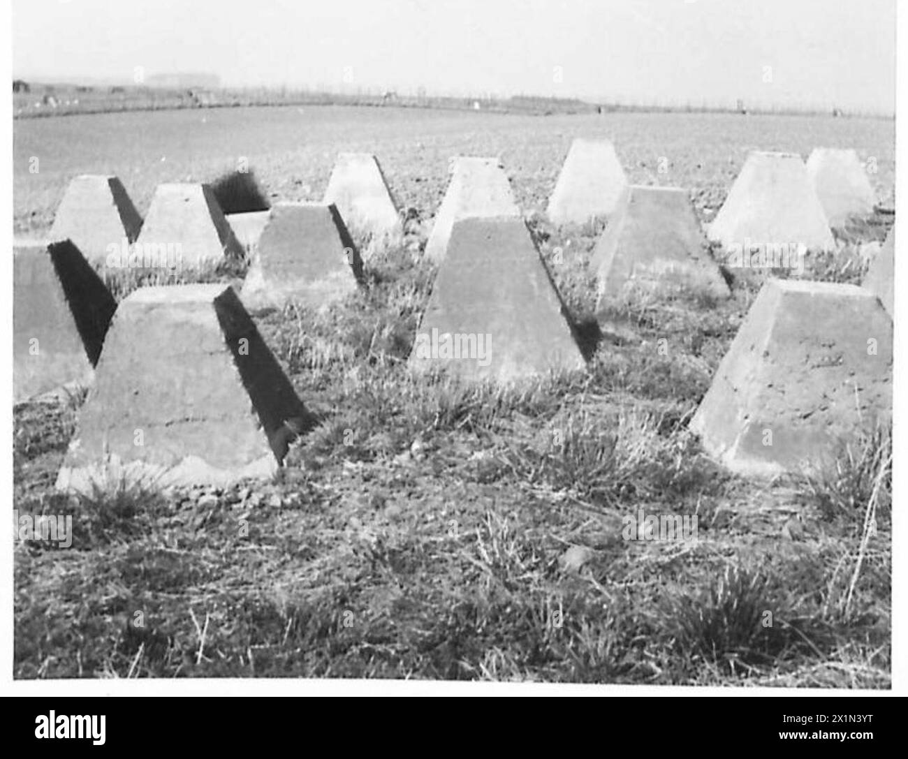 Gli ostacoli anticarro lungo la costa orientale del Lothian, tra cui Longniddry Bents e Hedderwick Sands, furono costruiti durante la seconda guerra mondiale per scoraggiare gli sbarchi nemici. Questi blocchi di cemento, spesso disposti in file, erano progettati per impedire il movimento di carri armati e veicoli. Alcuni resti rimangono visibili oggi, servendo come indicatori storici degli sforzi di difesa costiera in tempo di guerra. Foto Stock