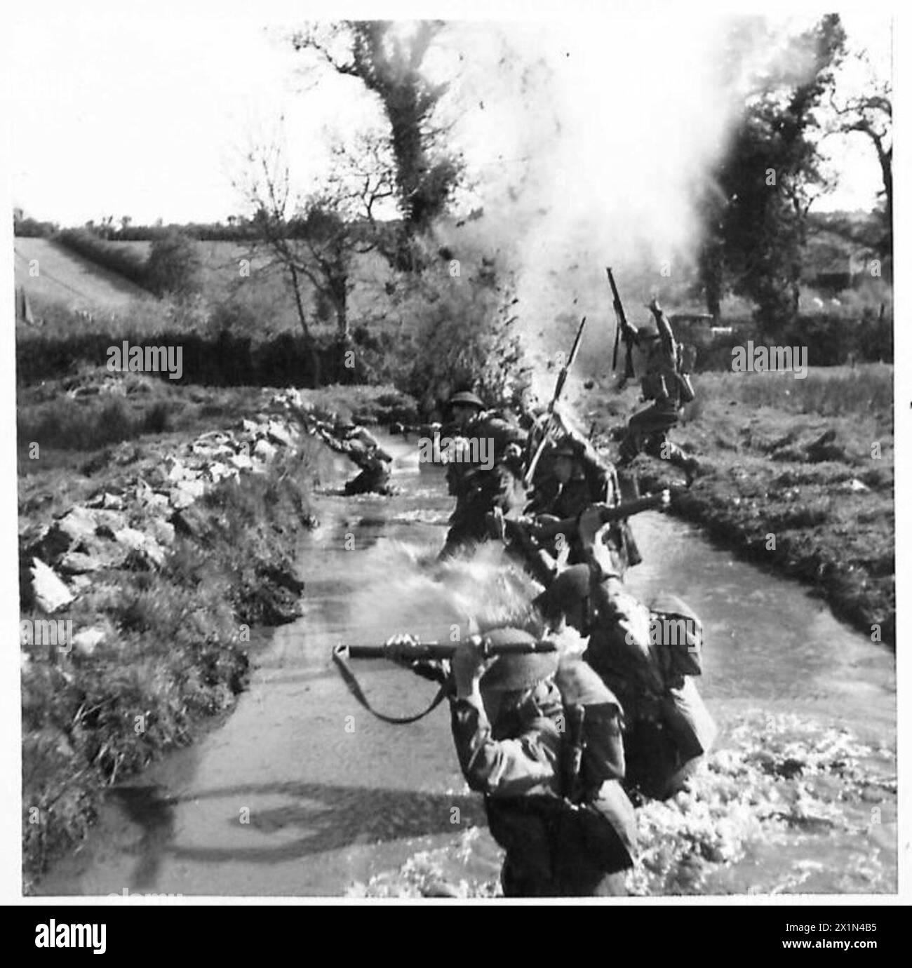 ADDESTRAMENTO SCUOLA DI BATTAGLIA - Una sezione che carica attraverso la "diga del lino" sotto fuoco, parte dei duri addestratori che vengono sottoposti alla School, British Army Foto Stock