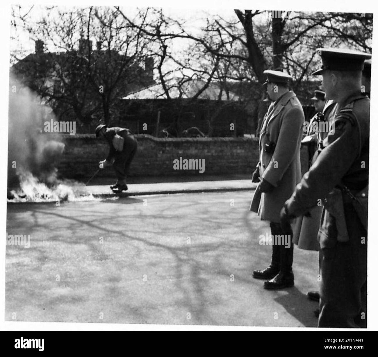 Il Duca di Gloucester osserva la combustione controllata di benzina in una trappola anticarro durante la sua visita alle difese costiere britanniche, dimostrando misure difensive. Foto Stock