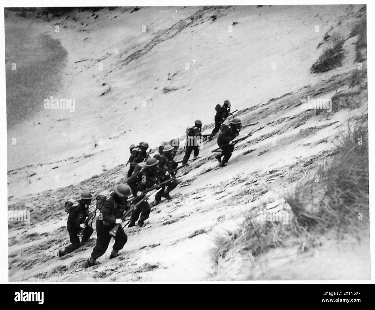 TRUPPE BELGHE IN ALLENAMENTO - Una squadra che arrampica sui lati ripidi di una duna di sabbia con le loro maschere antigas, British Army Foto Stock