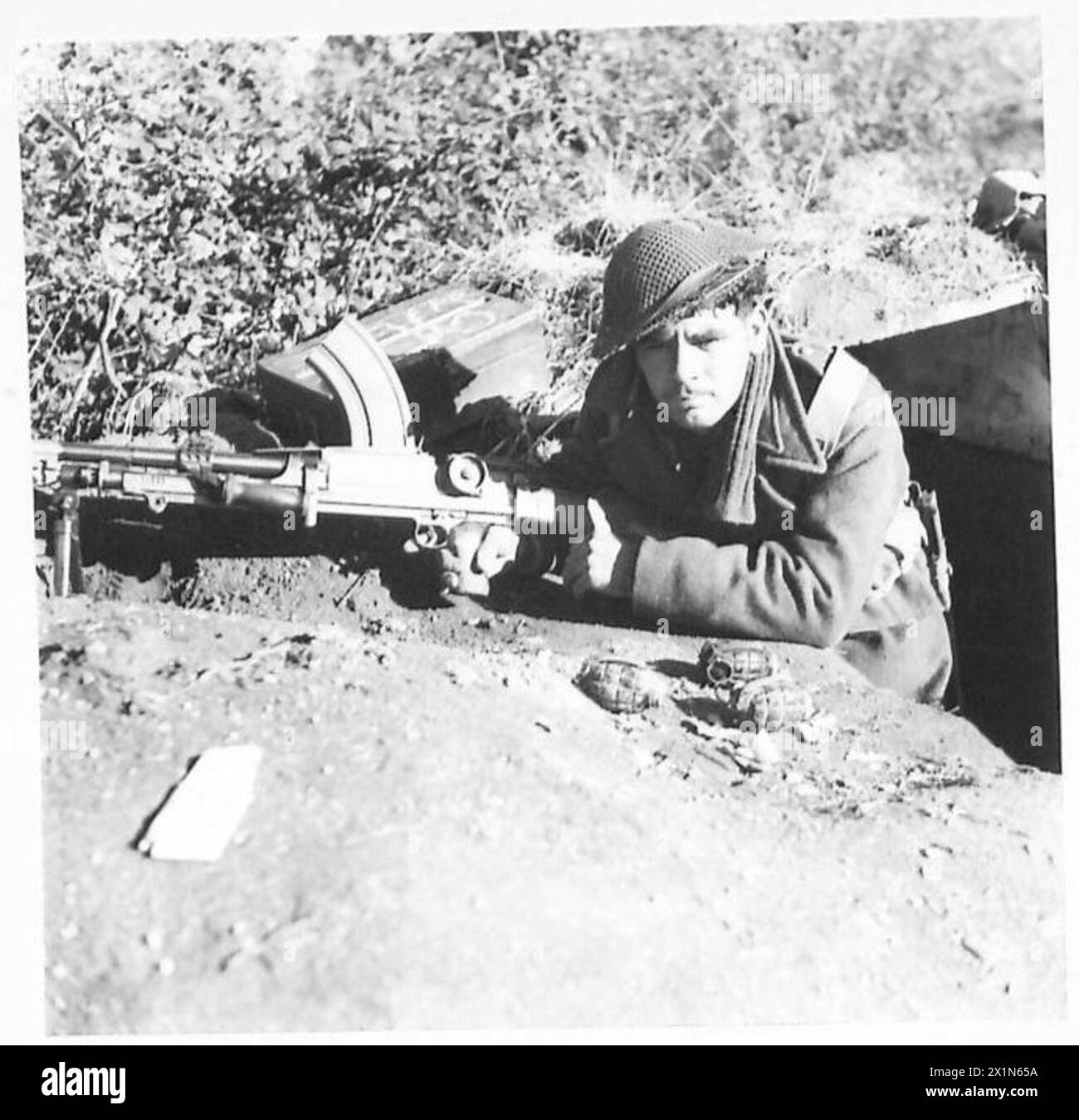 Il Rifleman A. Woods dell'esercito britannico controlla la Terra di No Man da una trincea in prima linea, armata con una pistola Bren e granate a mano. Foto Stock