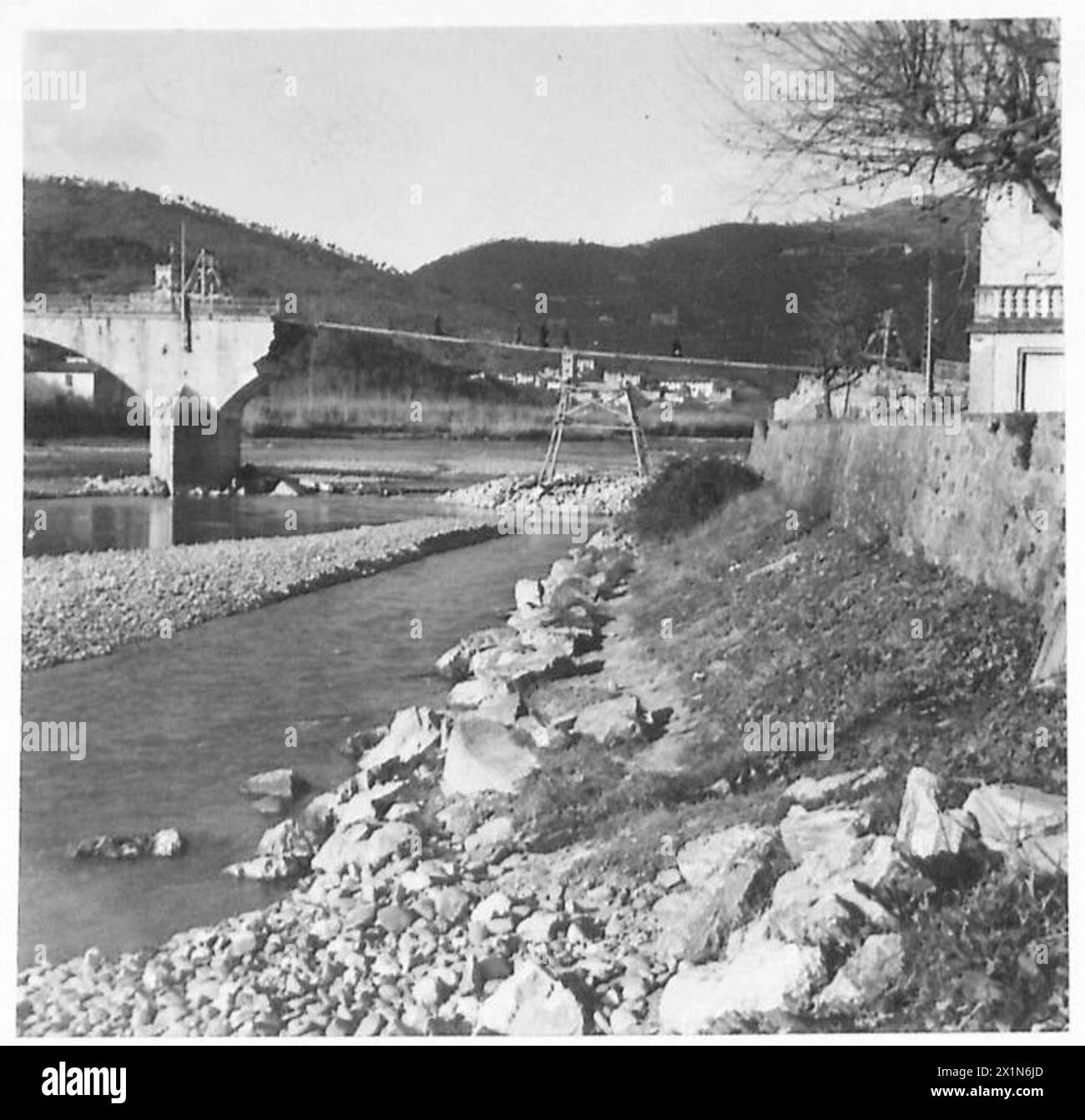 QUINTO ESERCITO : LA VALLE DEL SERCHIO - guardando lungo il fiume Serchio fino al ponte di grande campata distrutto dal nemico. Si vedono civili italiani attraversare il ponte sospeso eretto sopra il gap, British Army Foto Stock