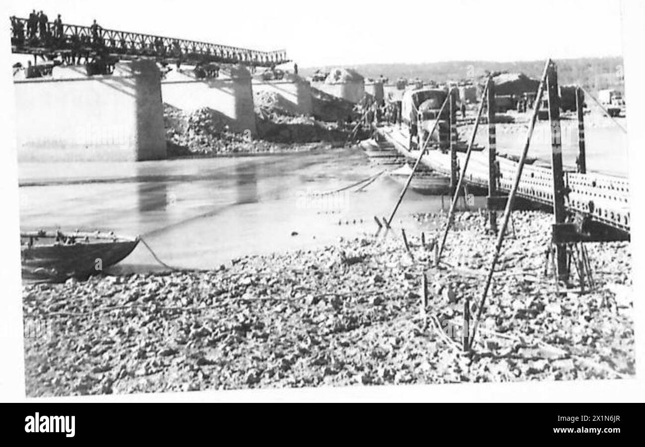 I veicoli dell'Ottava Armata britannica attraversano un fiume in Italia utilizzando un ponte temporaneo a una via, mentre un ponte più grande è in costruzione. Foto Stock