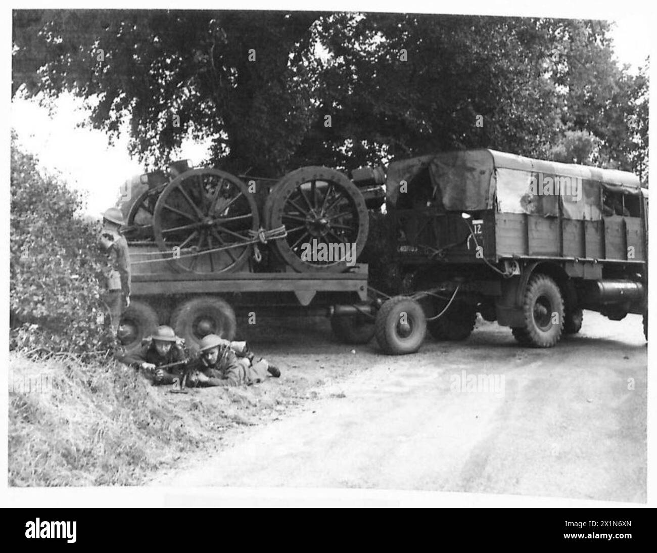 Una batteria d'artiglieria si ritira dall'azione mentre è protetta da un fucile anticarro, British Army. Foto Stock