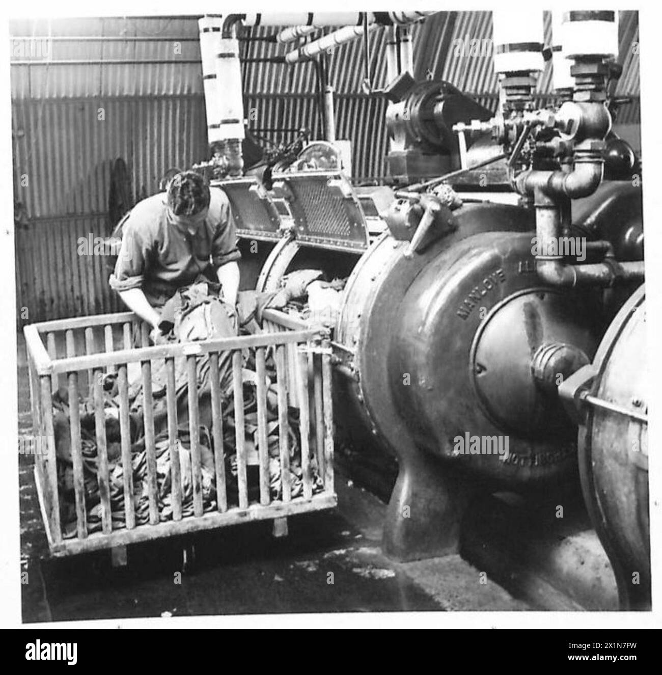 Il soldato J. Paddon dell'esercito britannico mette il bucato nelle lavatrici presso la lavanderia Orkneys, illustrando le procedure di pulizia dell'esercito. Foto Stock