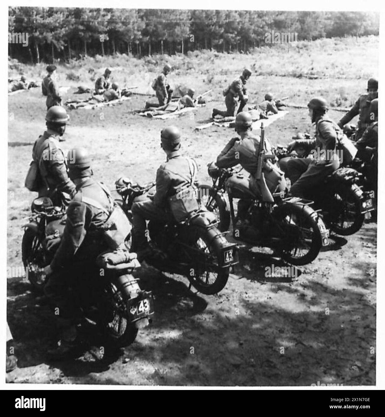 Un poliziotto militare riceve istruzioni su un campo di tiro mentre viene osservato dai colleghi in moto, British Army. Foto Stock