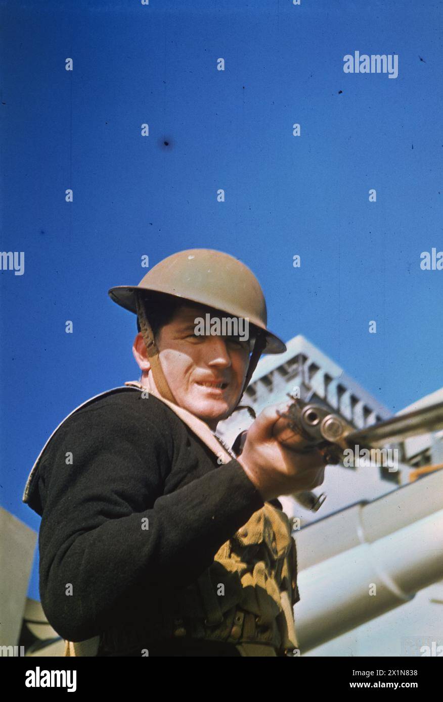 Un marinaio a bordo di una nave da battaglia nel novembre 1942 indossa un casco d'acciaio e trasporta un fucile con baionetta fissa, la Royal Navy. Foto Stock