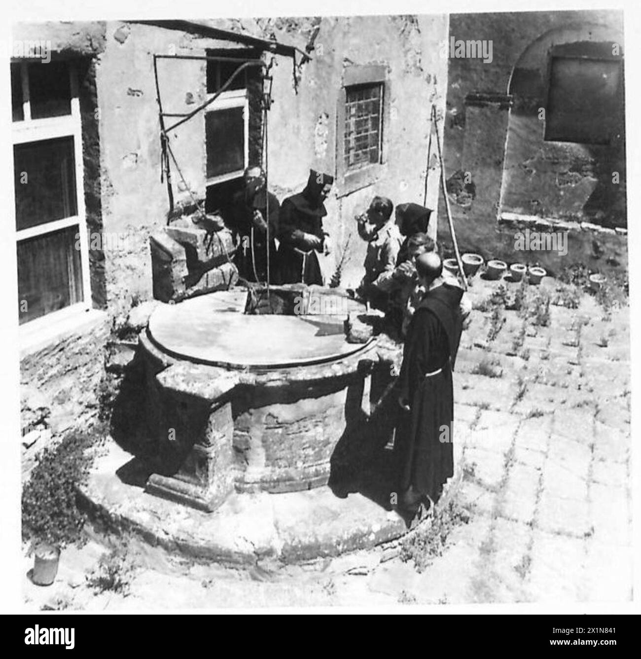 Due soldati britannici attingono acqua da un vecchio pozzo in un monastero che sfuggì ai danni di guerra, British Army. Foto Stock