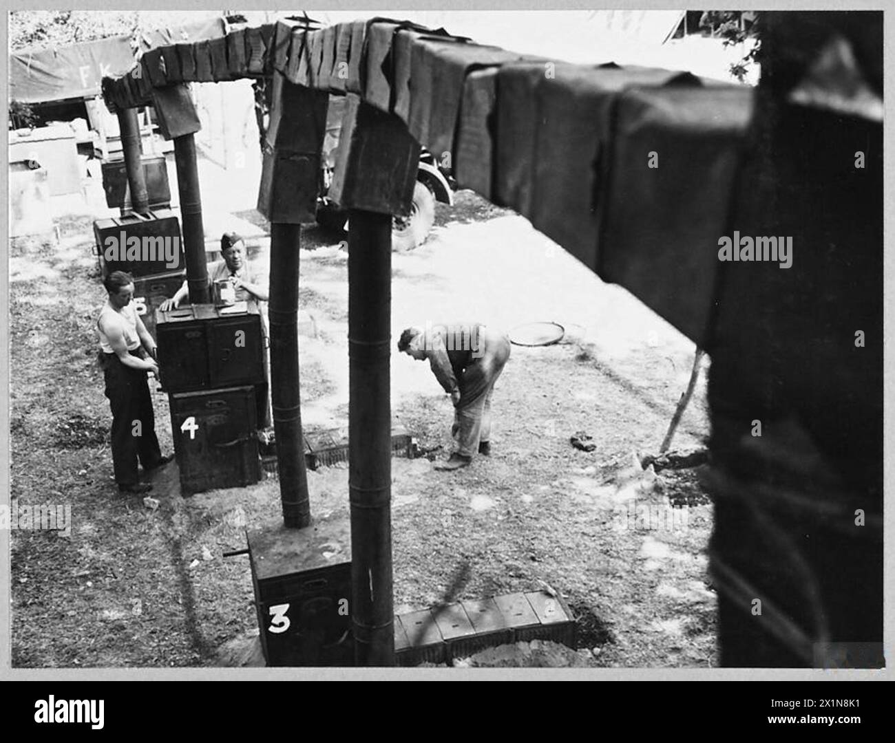 I cuochi della 2nd Tactical Air Force costruirono una cucina da campo nel 1944 utilizzando barattoli di benzina, fusti d'olio, sabbia e mattoni, tra cui un camino che indirizzava il fumo negli alberi vicini. Foto Stock