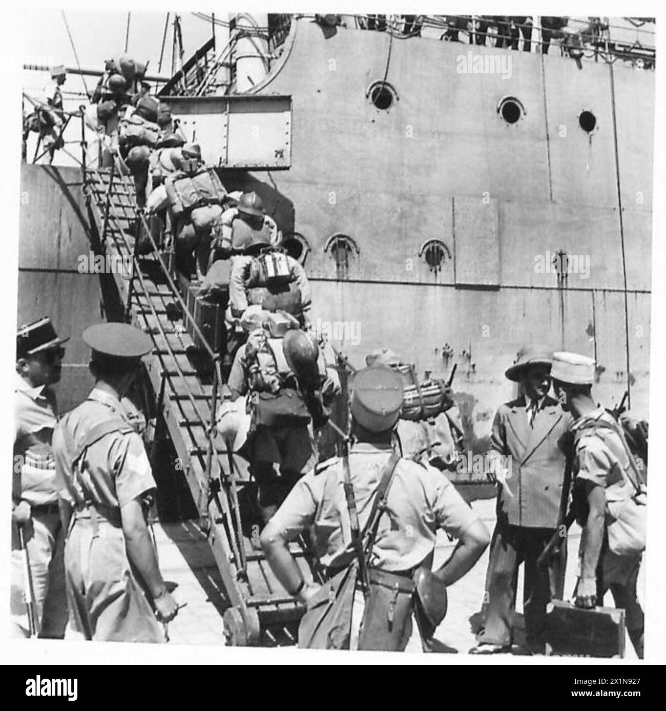 Le truppe di Vichy salgono a bordo delle barche per il rimpatrio a Tunisi sotto la supervisione dell'esercito britannico. Foto Stock