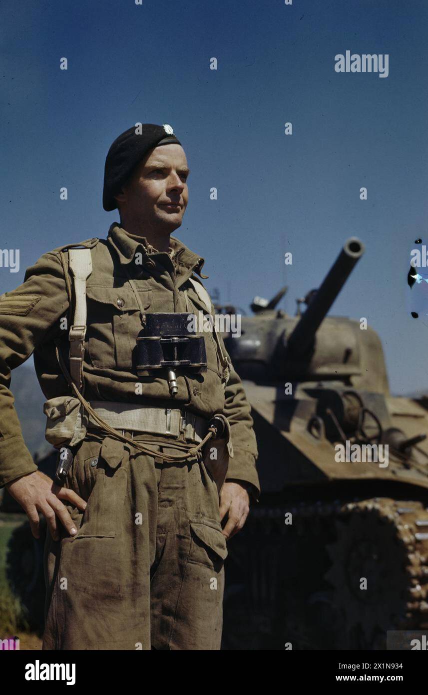 Il sergente A G Williams dei 17/21 Lancieri si trova accanto a un carro armato Sherman presso il quartier generale principale dell'Ottava Armata a San Angelo, in Italia, nell'aprile 1944, dopo lo schieramento dall'Inghilterra attraverso il Nord Africa. Foto Stock Il sergente A G Williams dei 17/21 Lancieri si trova accanto a un carro armato Sherman presso il quartier generale principale dell'Ottava Armata a San Angelo, in Italia, nell'aprile 1944, dopo lo schieramento dall'Inghilterra attraverso il Nord Africa. Foto Stock
