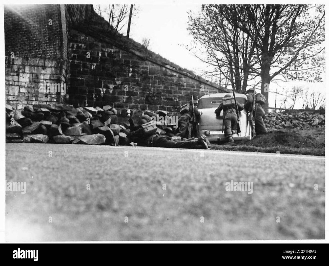 Il personale dell'esercito britannico sgombra un blocco stradale abbattendo le barriere e rimuovendo i veicoli che ostruiscono il percorso, garantendo mobilità e accesso. Foto Stock