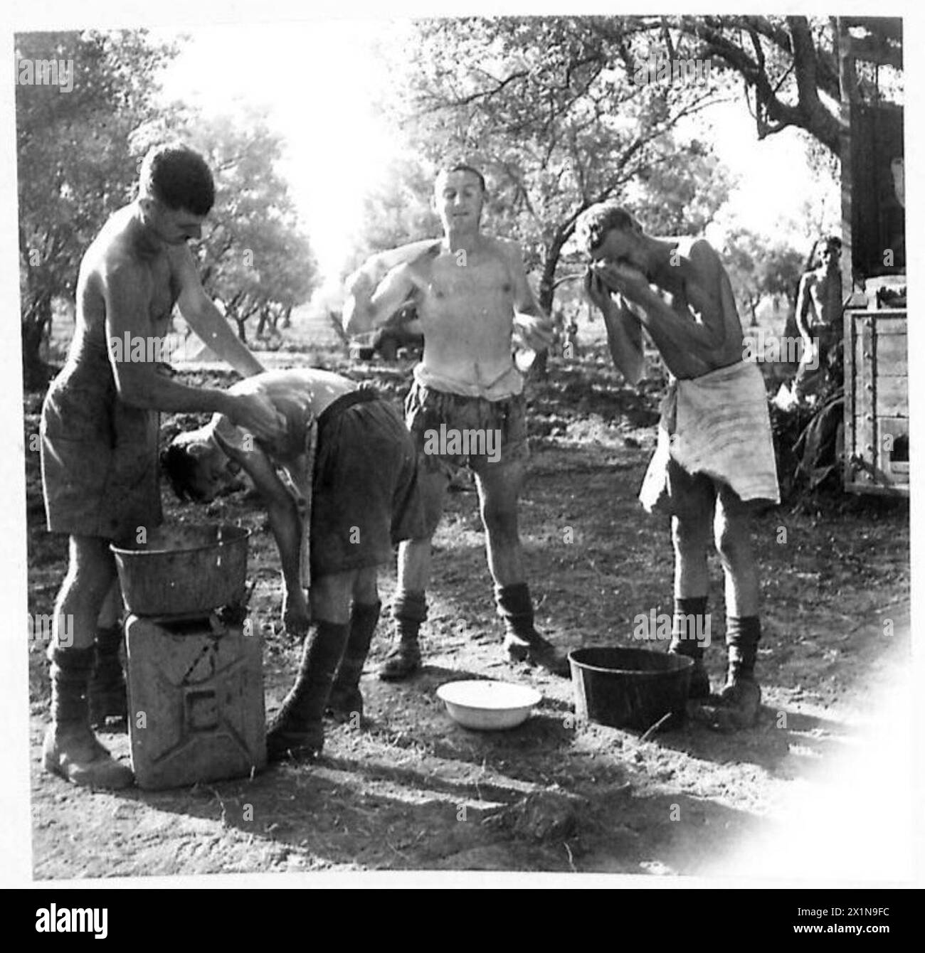 I cannonieri dell'ottava Armata puliscono l'equipaggiamento e se stessi all'arrivo in un nuovo sito, quindi visitano un villaggio vicino per rinfreschi durante un giorno nella vita della batteria, il British Army. Foto Stock