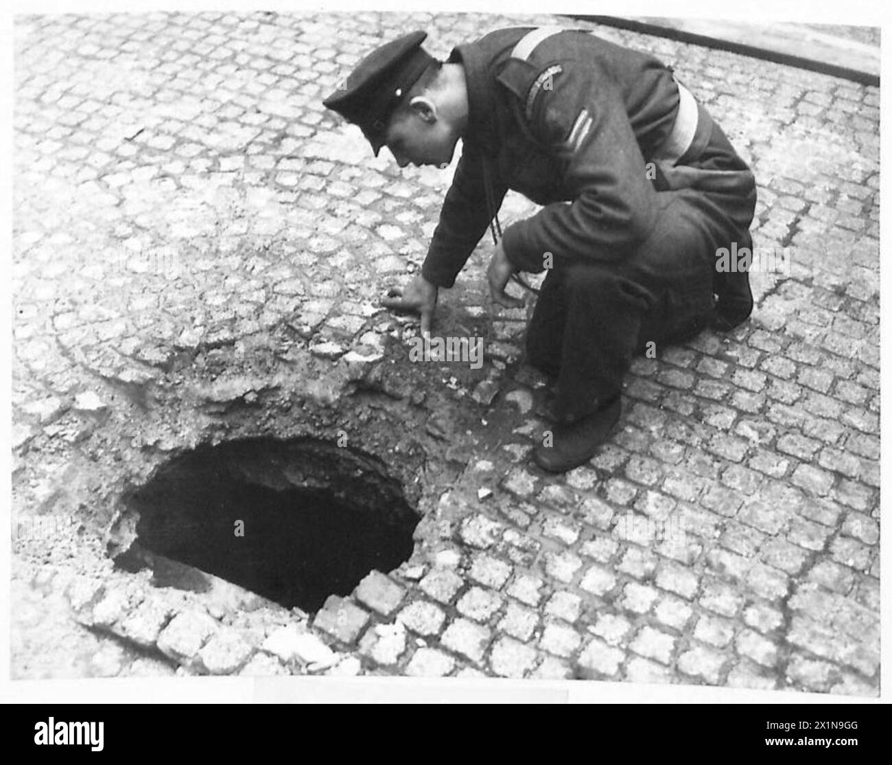Una bomba di un raid aereo tedesco atterra in una piazza quadrangolare a Londra, lasciando un buco, l'esercito britannico. Foto Stock
