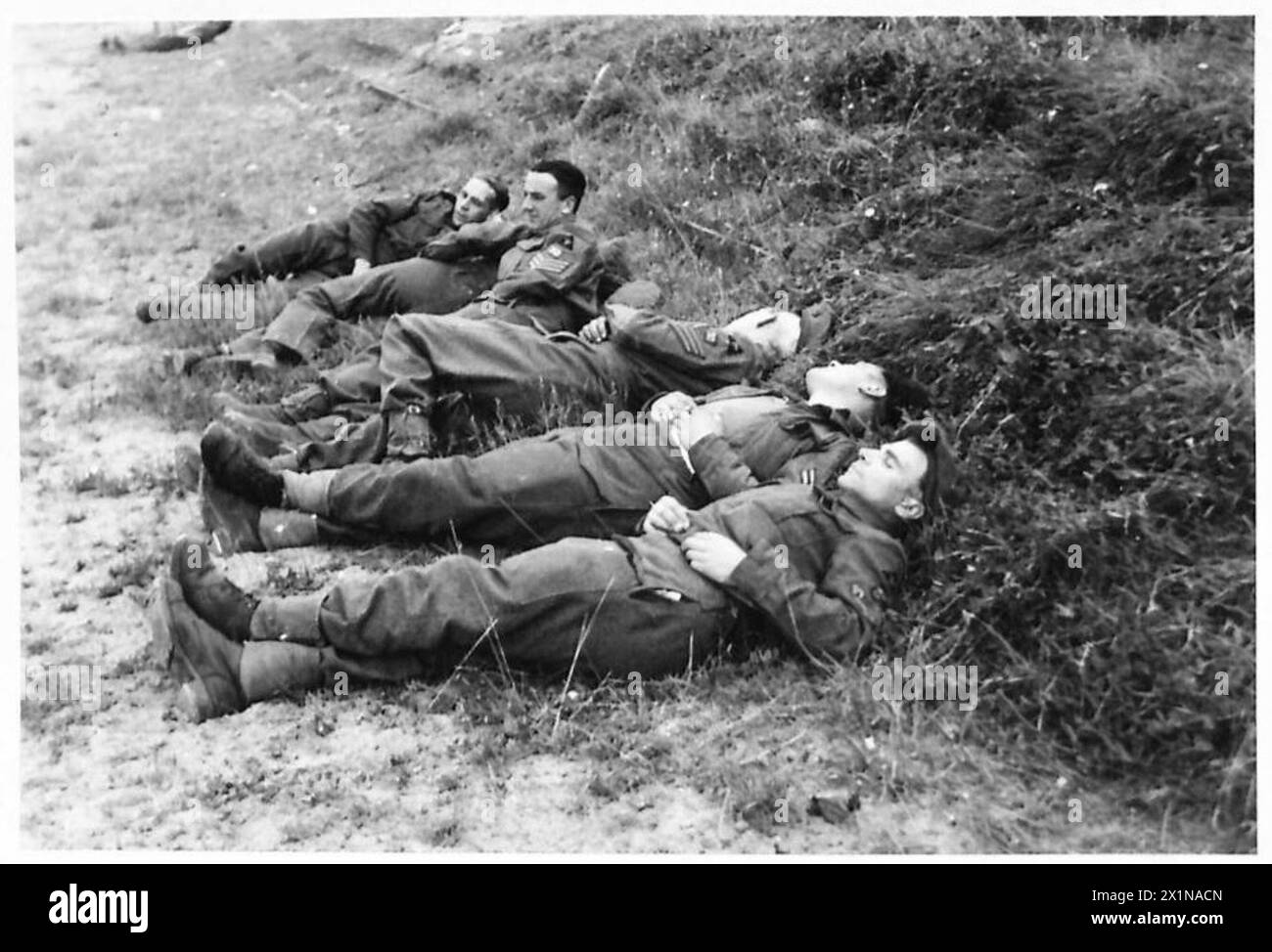 Soldati britannici tra cui Sapper A. Whamond, i sergenti J. Corcoran e C. Priscott, il caporale A. Talbot e il caporale W. Hater riposano sulla spiaggia di fronte ad un ex hotel di lusso francese convertito in un club di riposo, British Army, 21st Army Group. Foto Stock
