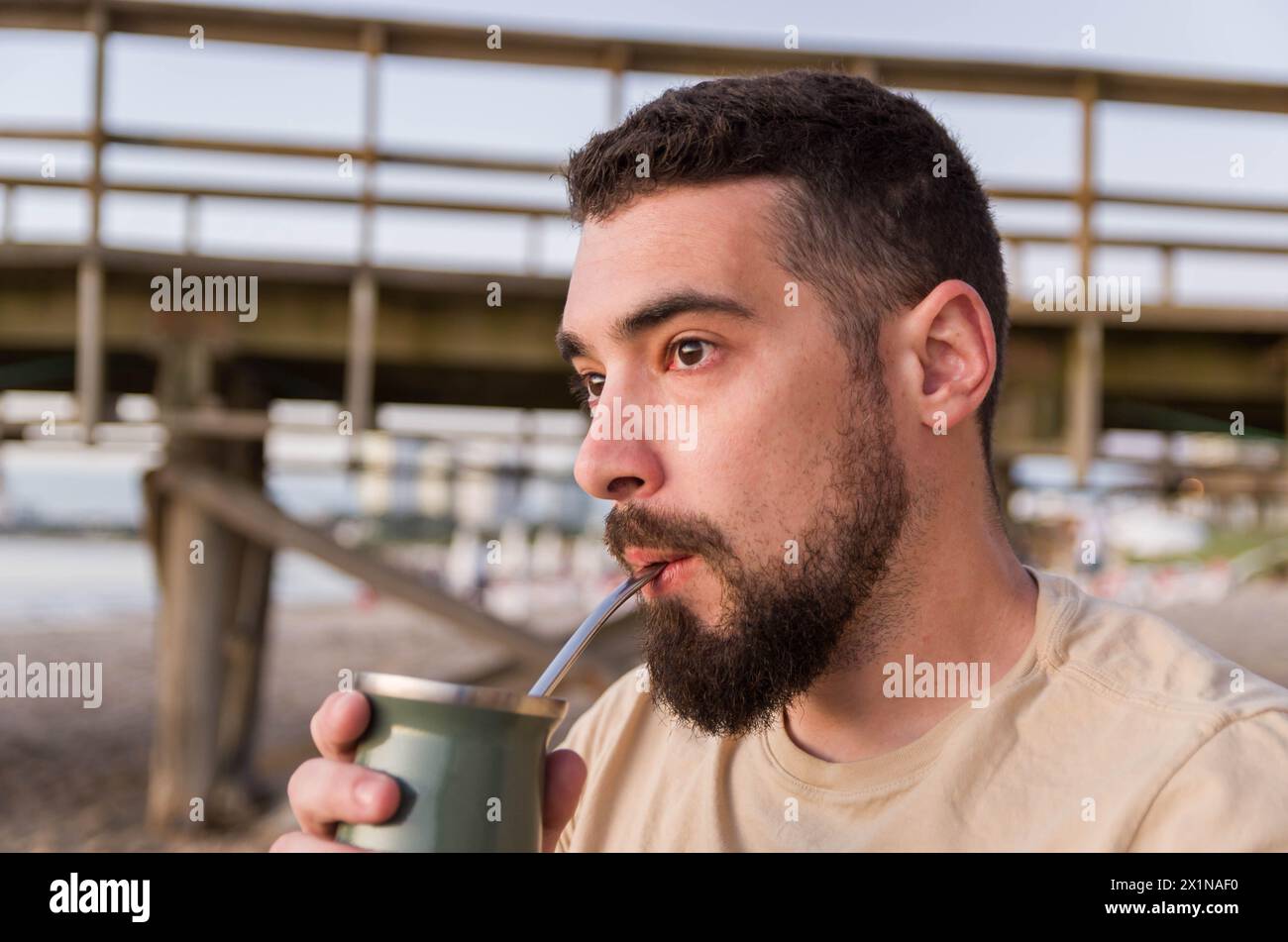 Uomo che beve chimarrão, mate (un'infusione di yerba mate con acqua calda) al tramonto in uruguay Foto Stock