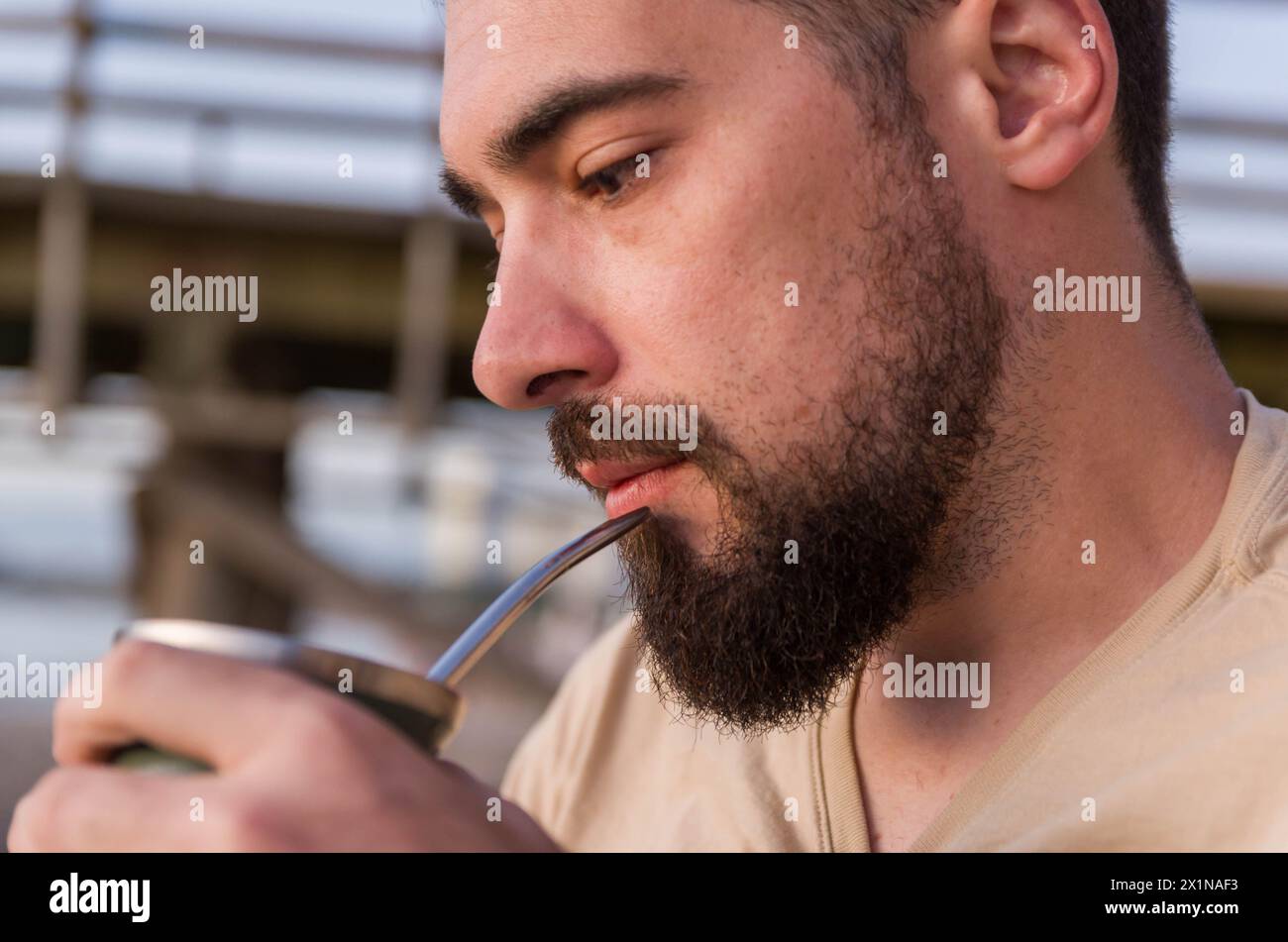 Uomo che beve chimarrão, mate (un'infusione di yerba mate con acqua calda) al tramonto in uruguay Foto Stock