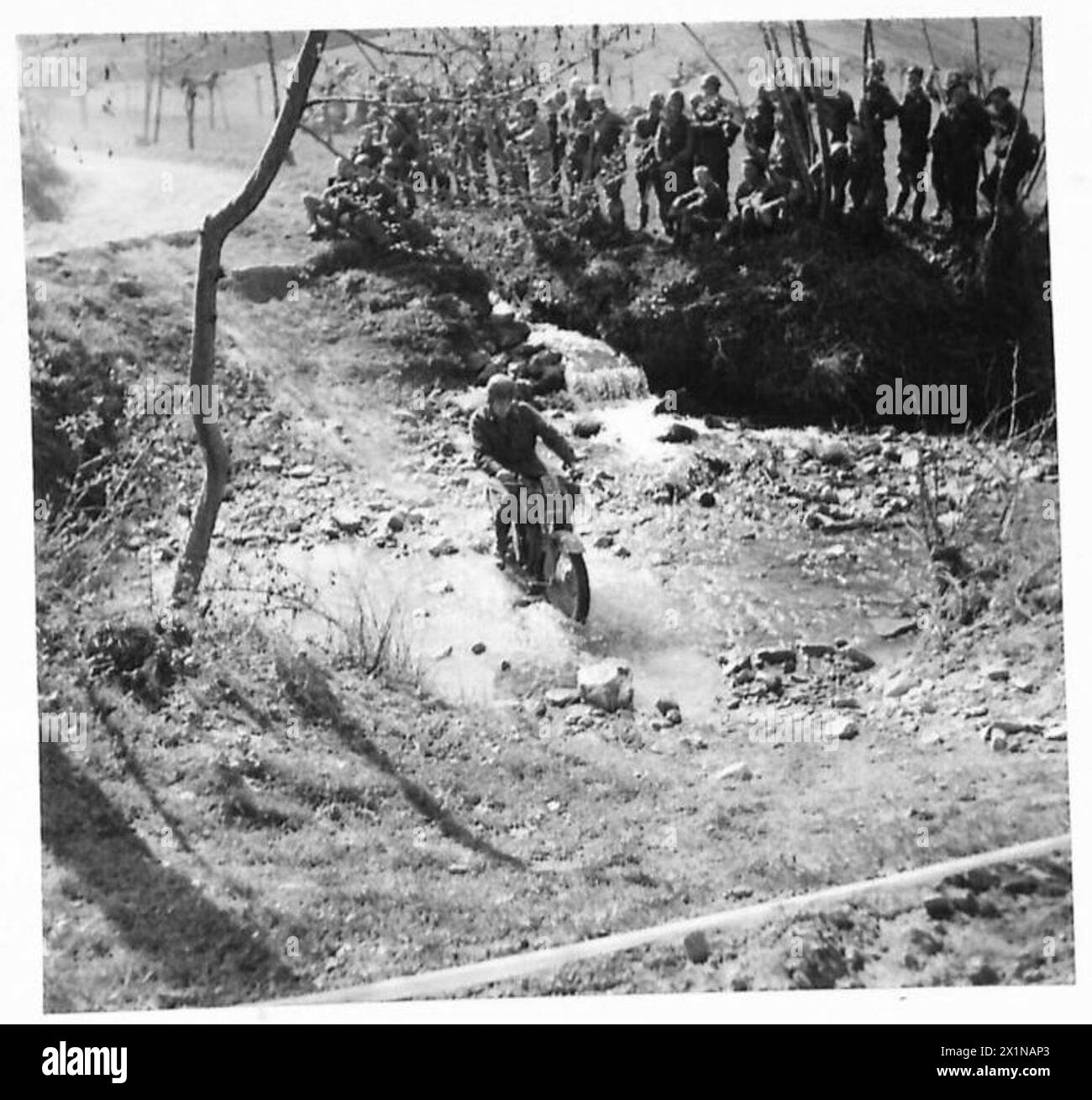 N. 3 L/Sgt. W. Matthews del 578 Field Coy., R.E., negozia un ruscello poco profondo, una ripida riva e una brusca svolta a destra durante il processo per moto del 13 Corps. Foto Stock