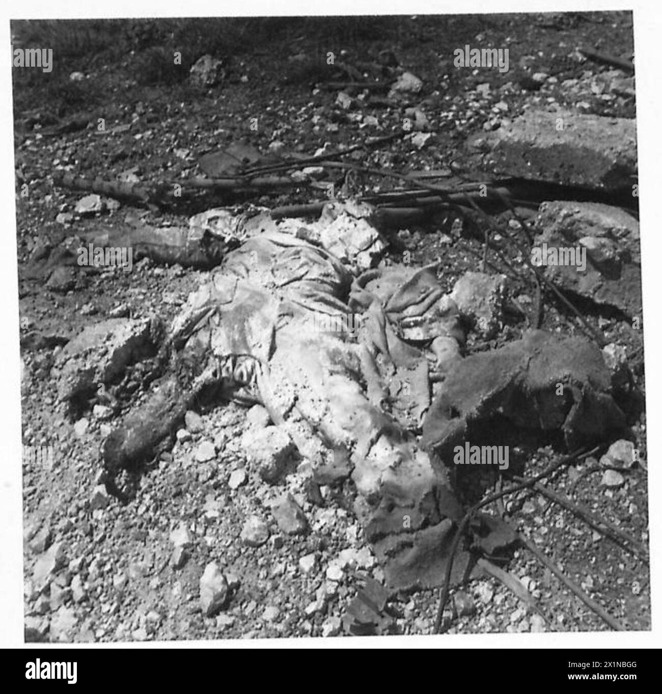 Un soldato caduto si vede a Cassino, in Italia, durante le operazioni condotte dall'esercito britannico nella cattura della città, riflettendo l'ambiente di combattimento della battaglia. Foto Stock