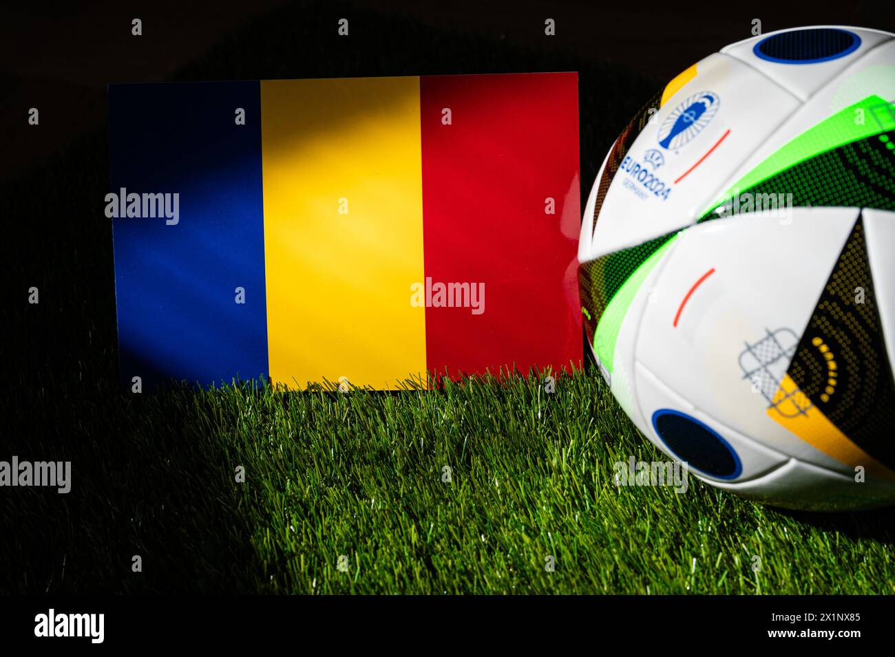 MONACO DI BAVIERA, GERMANIA, 17 APRILE 2024: Bandiera nazionale rumena e pallone ufficiale di calcio del torneo di calcio Euro 2024 in Germania piazzato su erba verde. Bla Foto Stock