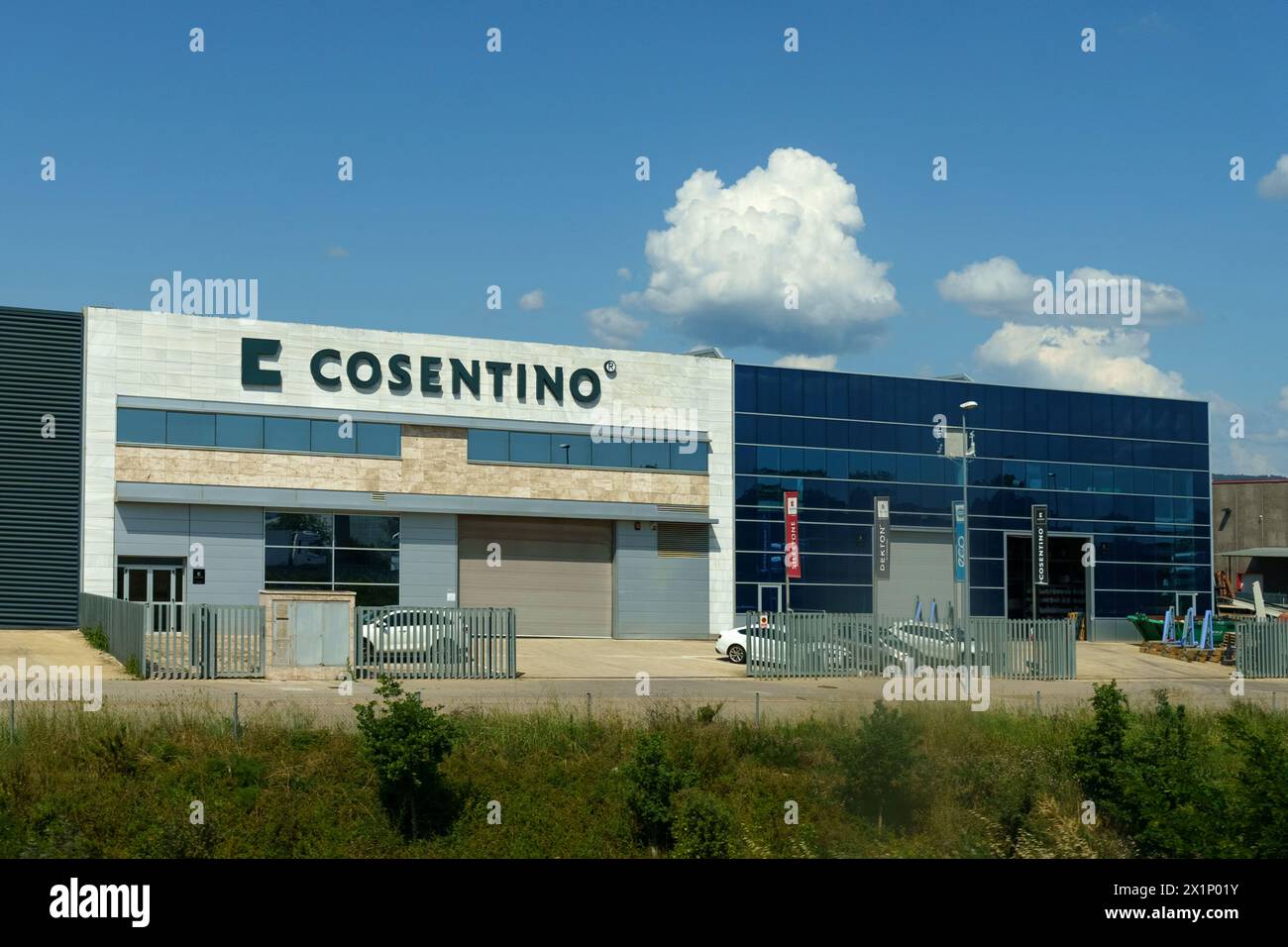 Barcellona, Spagna - 24 maggio 2023: La facciata moderna dell'edificio Cosentino con la sua segnaletica chiara, le finestre blu e un cielo pieno di nuvole Foto Stock