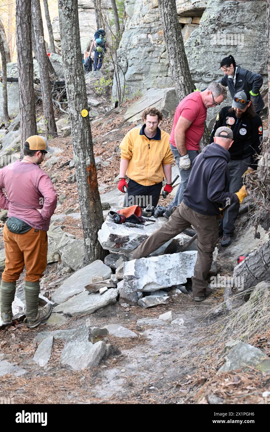 Un equipaggio addetto alla manutenzione dei sentieri lavora per rimuovere una grande roccia che è caduta dalla scogliera sul sentiero sottostante al Pilot Mountain State Park nel North Carolina. Foto Stock