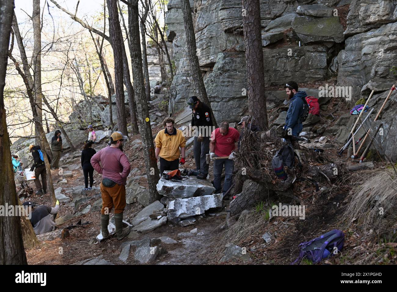 Un equipaggio addetto alla manutenzione dei sentieri lavora per rimuovere una grande roccia che è caduta dalla scogliera sul sentiero sottostante al Pilot Mountain State Park nel North Carolina. Foto Stock