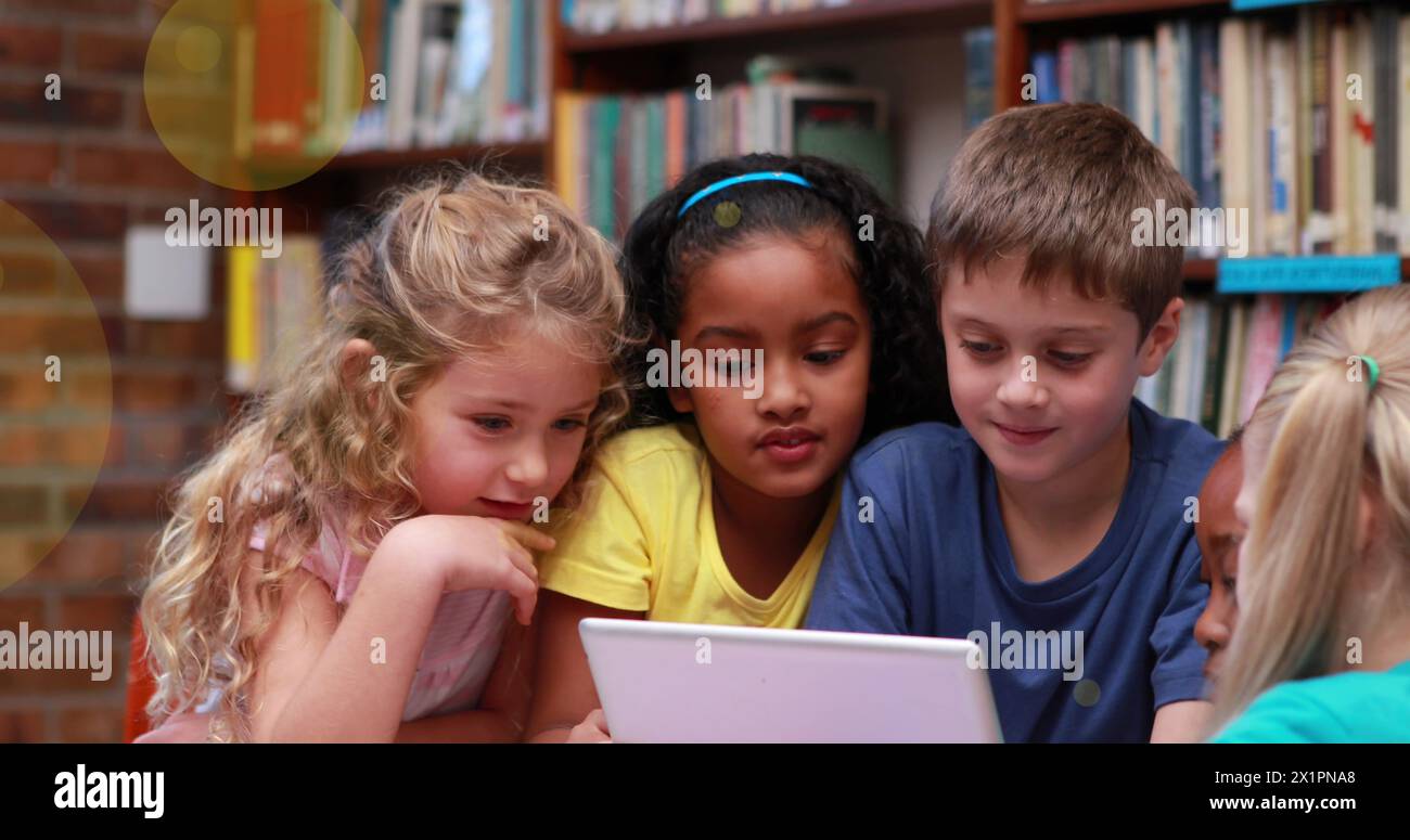 A scuola, un gruppo diversificato di giovani studenti che si concentrano sui tablet Foto Stock