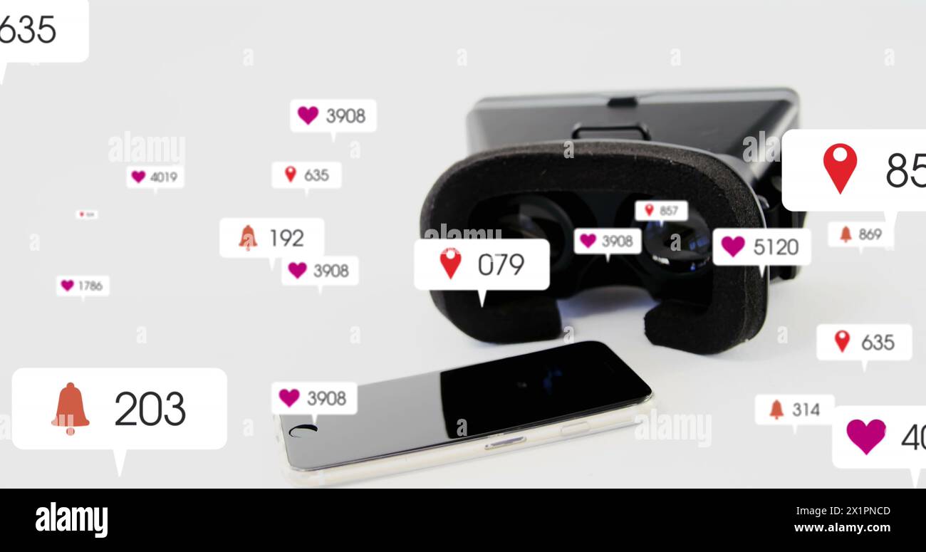 Un visore VR e uno smartphone si trovano su un tavolo circondato da icone dei social media Foto Stock