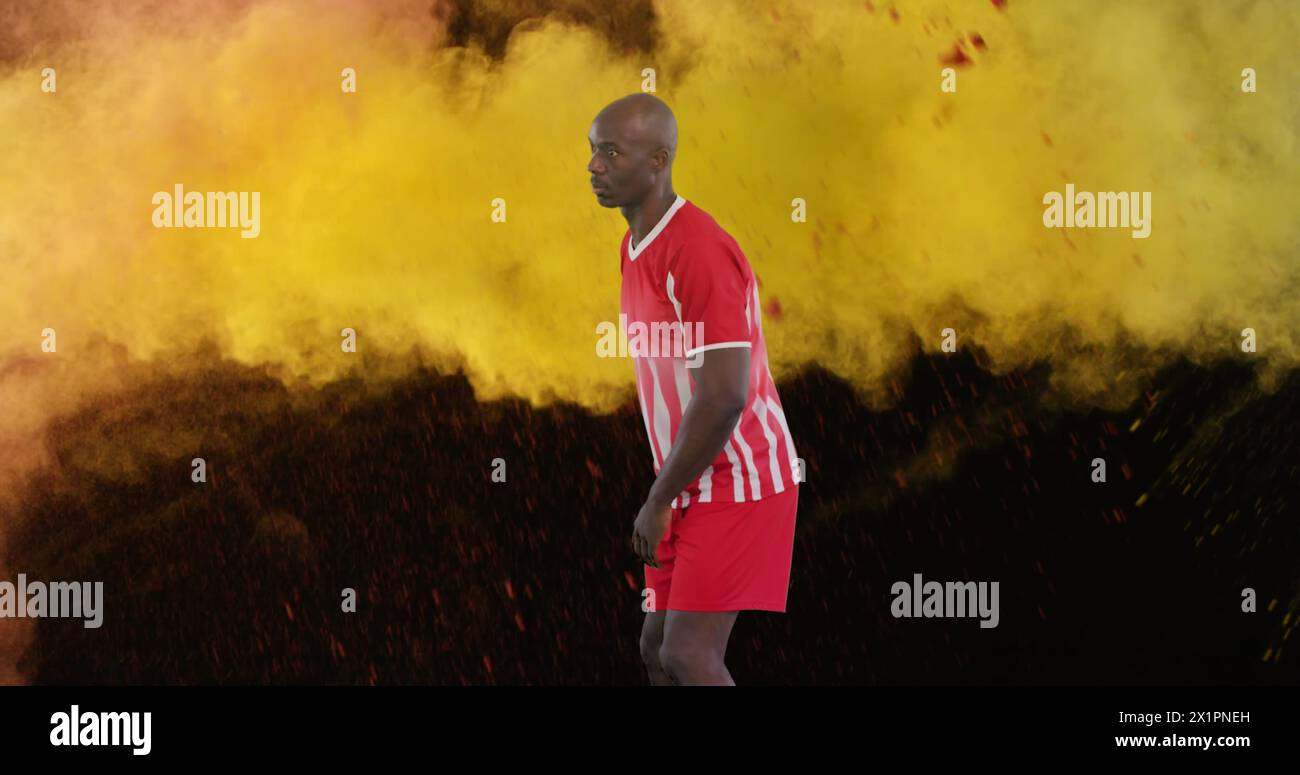Uomo in divisa da calcio a strisce rosse e bianche che cammina attraverso il fumo colorato sul campo Foto Stock
