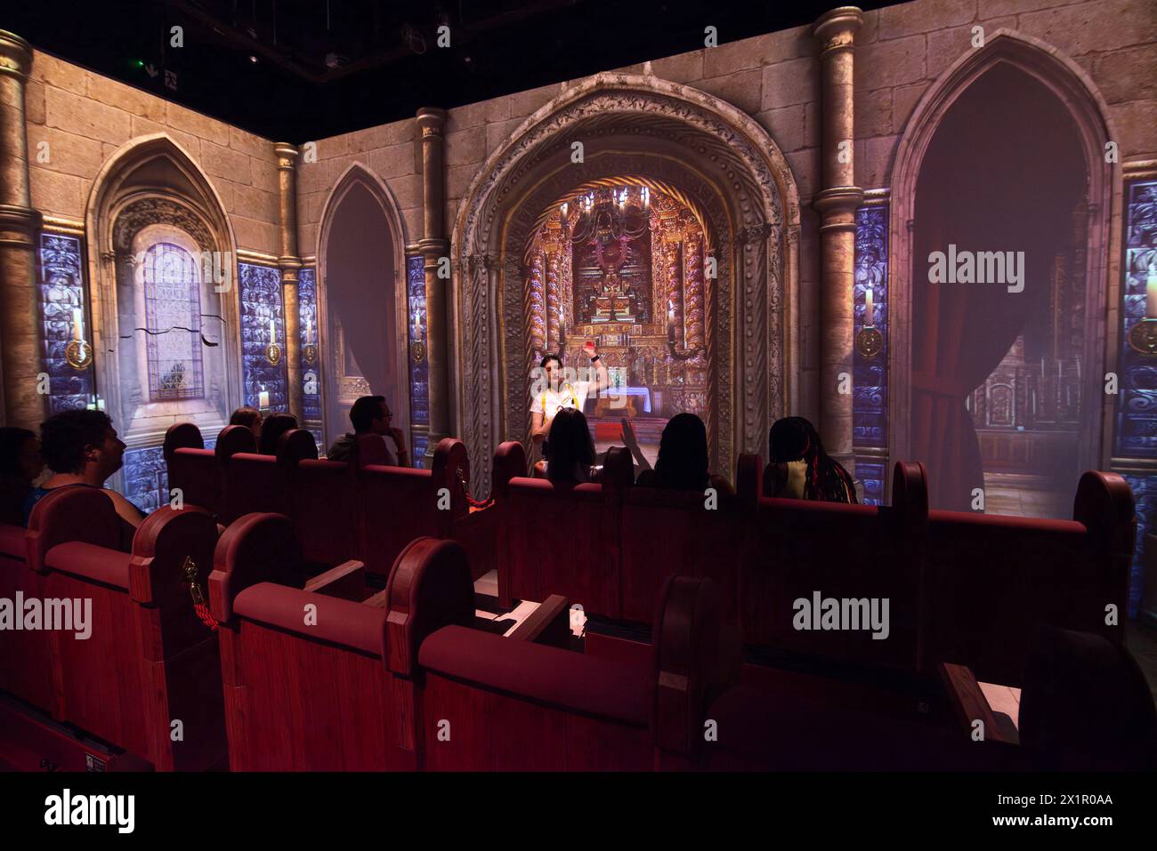 QUAKE Lisbon EARTHQUAKE Museum, Centro do Terramoto De Lisboa, Belém, Lisbona, Portogallo. Un gruppo di visitatori siede all'interno di pali mentre una proiezione video dell'interno della chiesa di São Nicolau è proiettata sulle pareti del museo. Un dipendente del museo descrive l'esperienza del terremoto prima di una simulazione in cui il pavimento tremerà e il video mostrerà il fuoco e il crollo dell'edificio della chiesa. Il Museo di 1.800 metri quadrati dedicato al grande terremoto di Lisbona del 1755 è stato aperto al pubblico nell'aprile 2022. Foto Stock