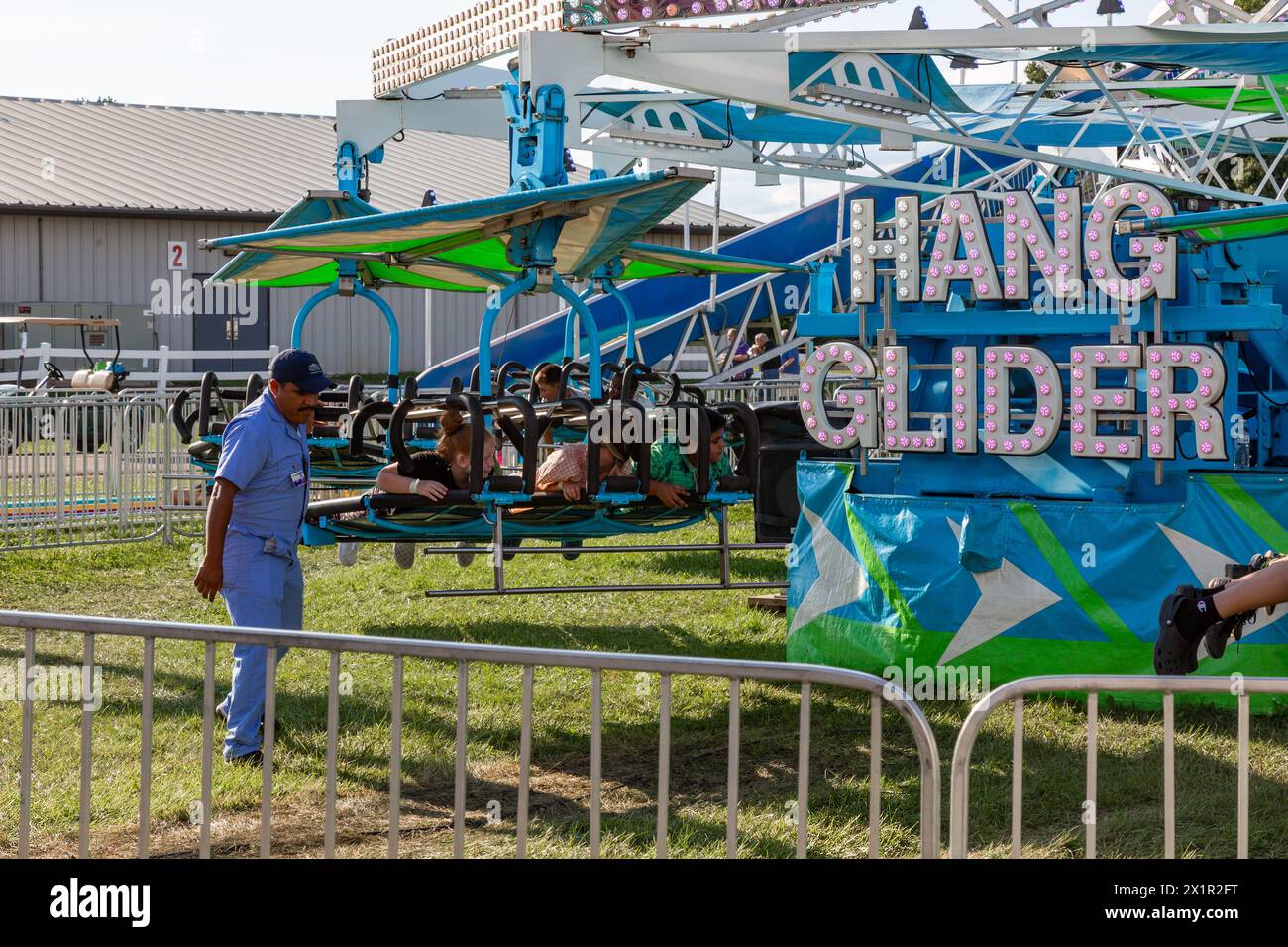 L'operatore di divertimenti del carnevale assiste nel movimento della corsa "Hang Glider" alla Allen County Fair di Fort Wayne, Indiana, USA. Foto Stock