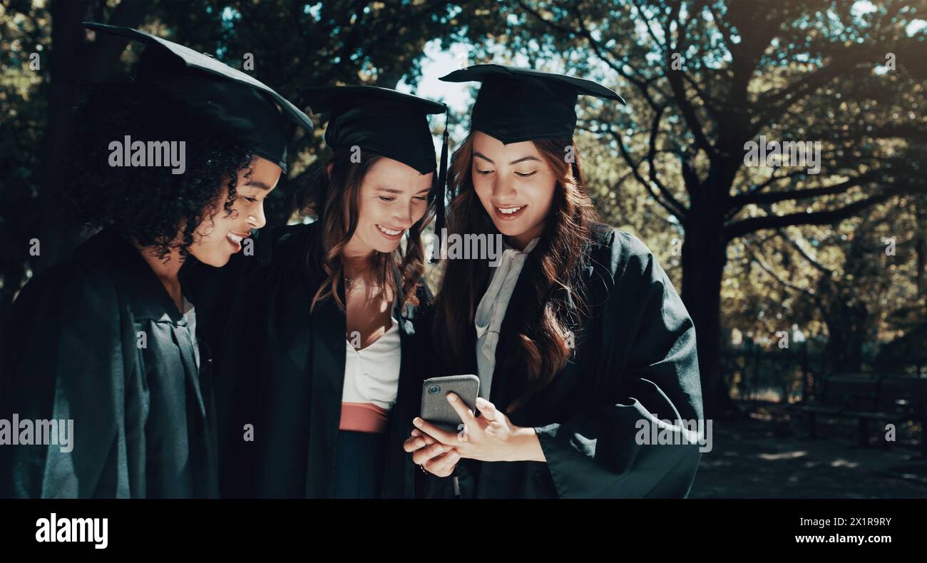 Studenti, telefono e risultati per la laurea all'aperto con social media, successo accademico e lettura di testi. Donne, fuori e laurearsi insieme Foto Stock