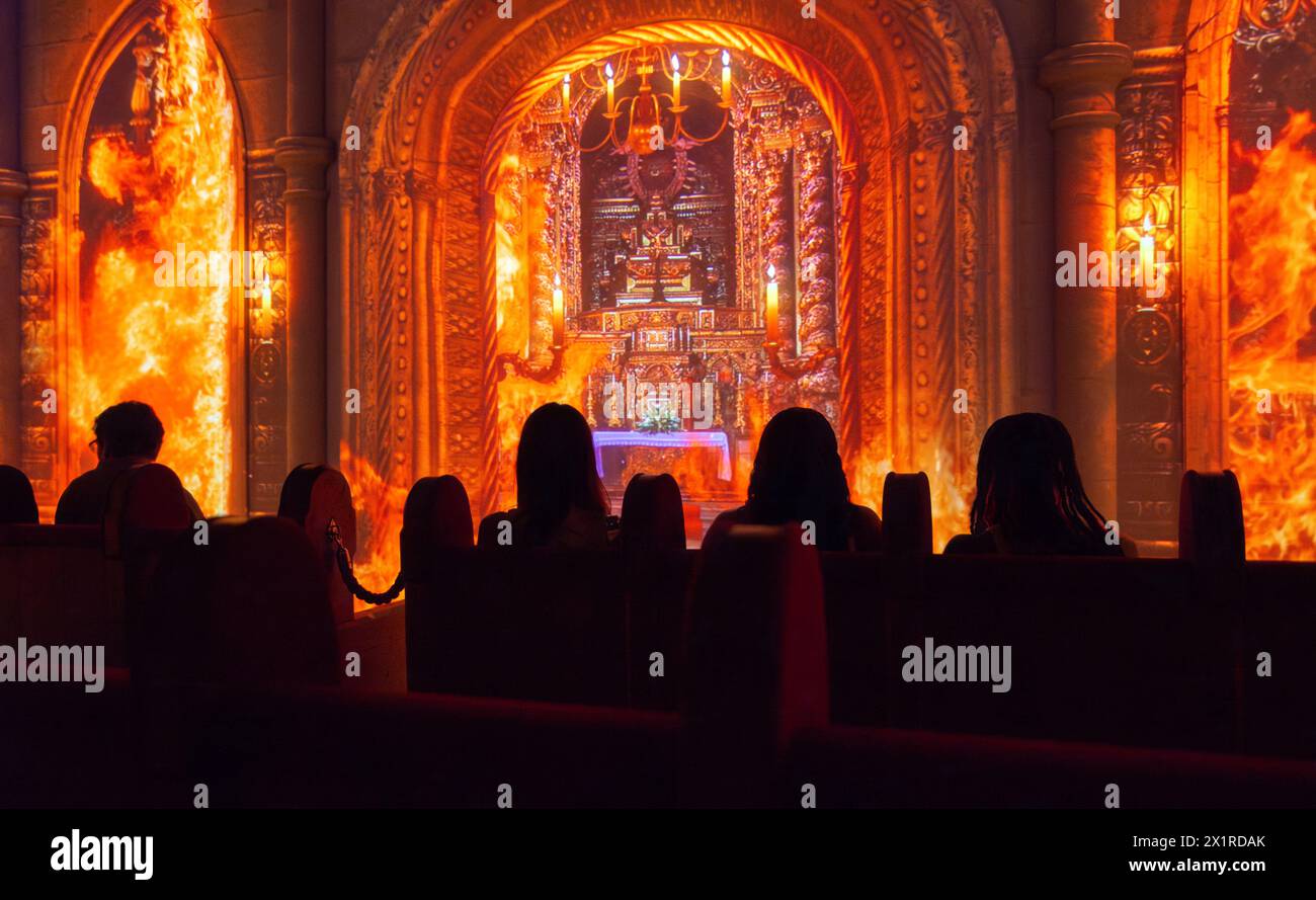 QUAKE Lisbon EARTHQUAKE Museum, Centro do Terramoto De Lisboa, Belém, Lisbona, Portogallo. In una grande sala del museo, un gruppo di visitatori siede sulle cime come una proiezione video dell'interno della chiesa di São Nicolau in fiamme dopo il terremoto del 1755. Durante la simulazione il pavimento tremerà e il video mostrerà l'incendio e il crollo dell'edificio della chiesa. Il Museo di 1.800 metri quadrati dedicato al grande terremoto di Lisbona del 1755 è stato aperto al pubblico nell'aprile 2022. Foto Stock